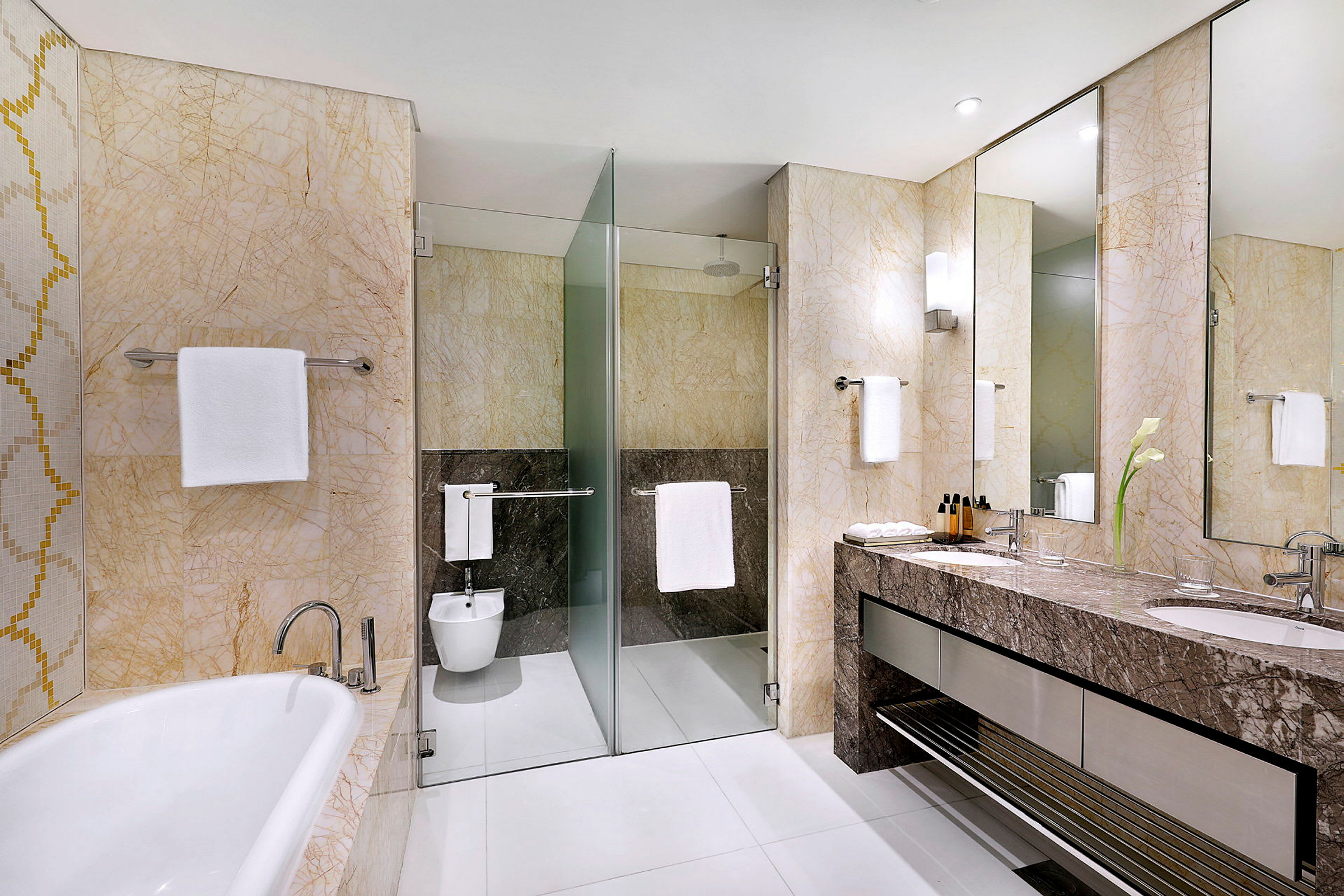 Et moderne bad med badekar, dusj med glassvegg, bidet og servant med speil. (AI-generert tekst)