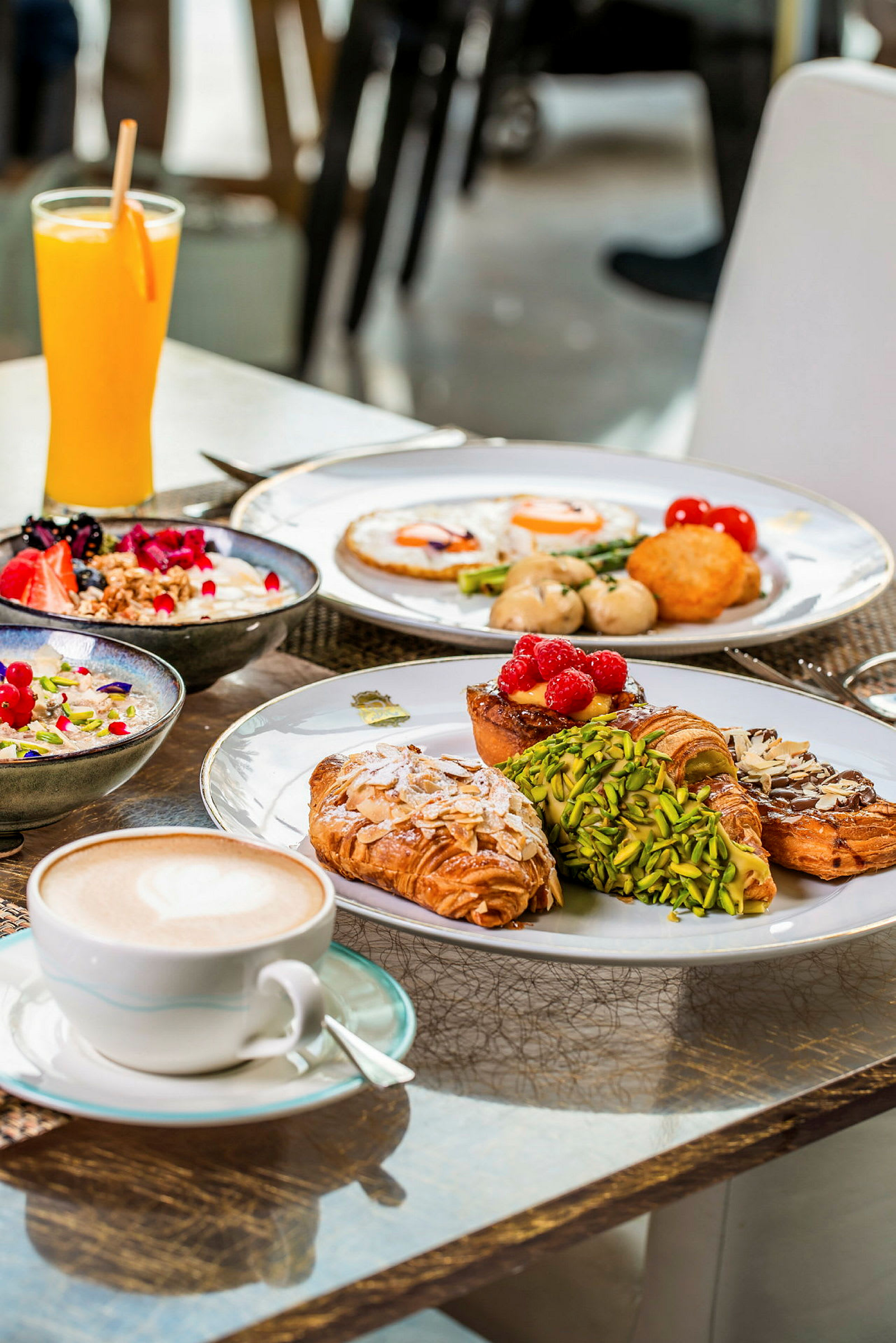 En borddekor med forskjellige frokostalternativer, inkludert bakverk, ferske bær, juice og kaffe. (AI-generert tekst)