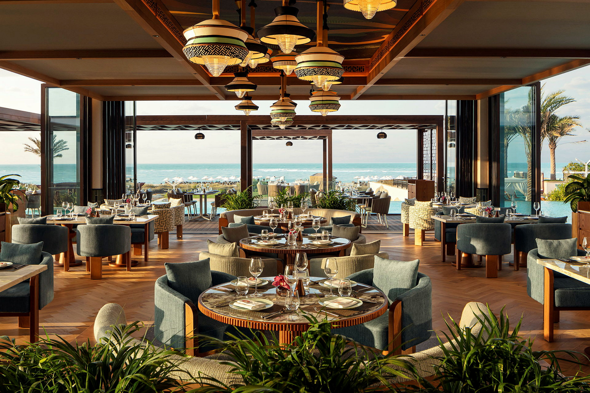 En restaurant med bord dekket og utsikt mot havet. (AI-generert tekst)