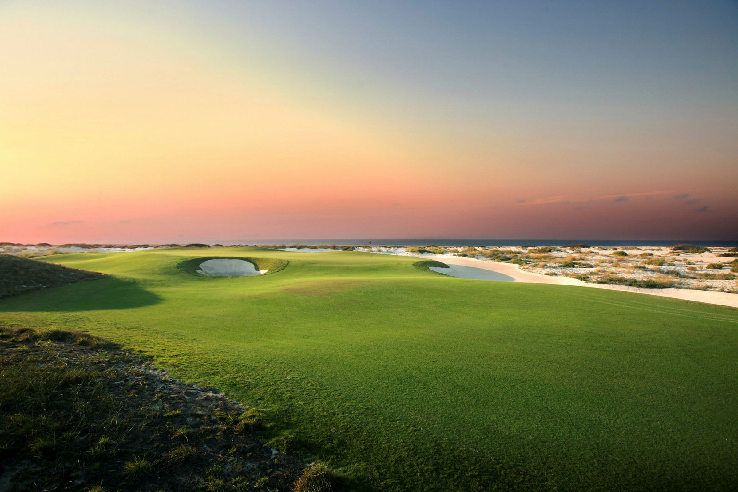 Golfbane nær kysten ved solnedgang. (AI-generert tekst)