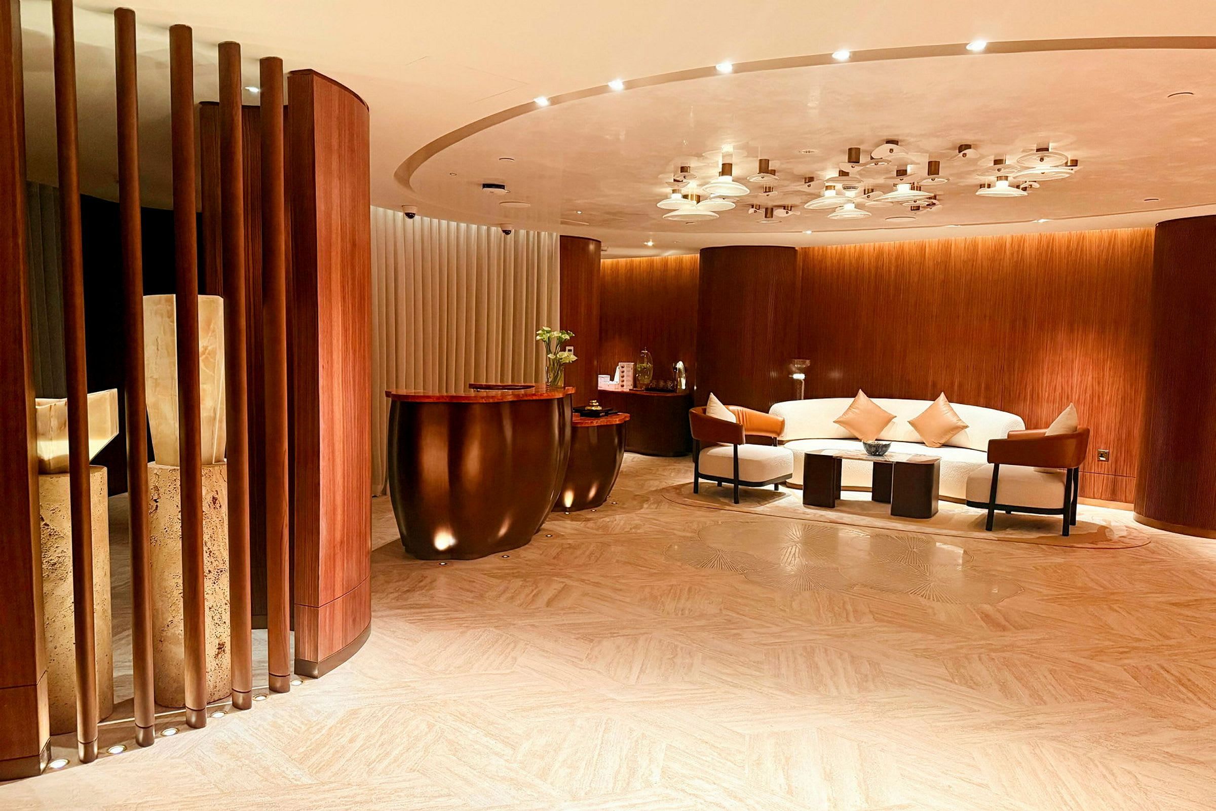 Et stilfullt hotell- eller kontorområde med sofagruppe, sofabord og marmordetaljer, omgitt av trepanelvegger. (AI-generert tekst)