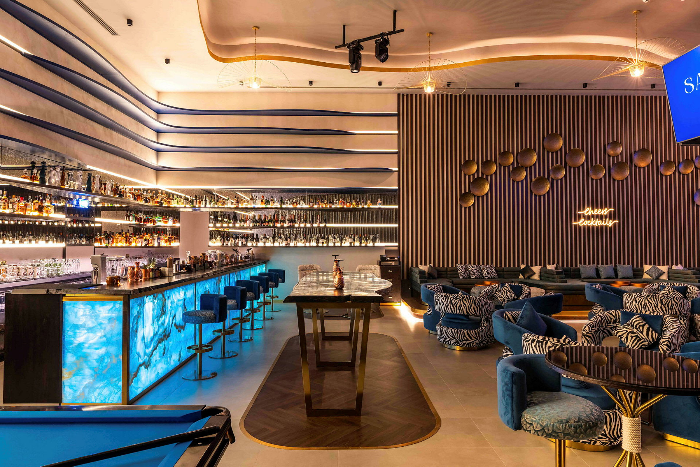 Moderne innredet bar med blå belysning og loungeområde. (AI-generert tekst)