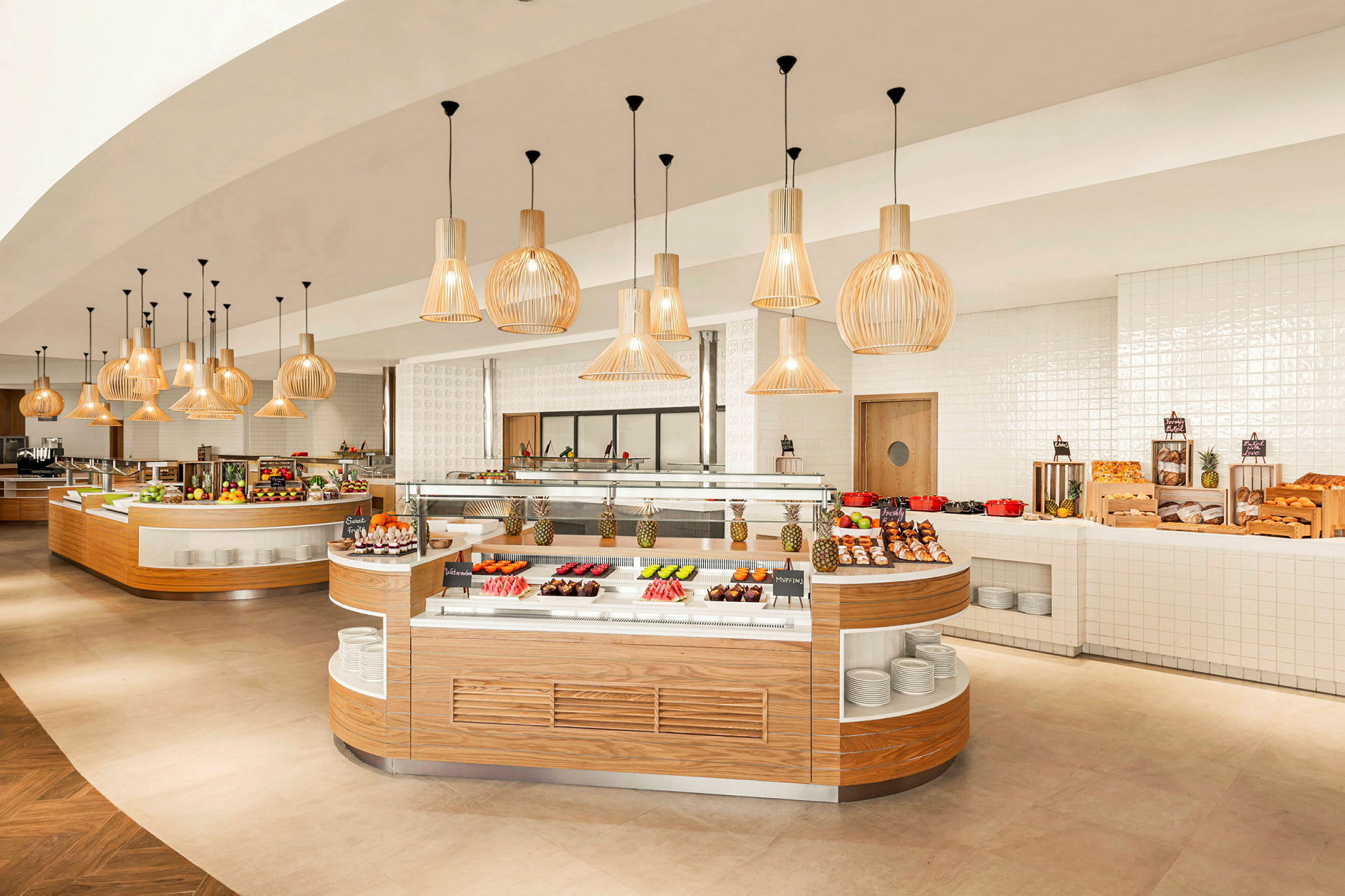 En restaurantbuffé med ulike retter og frukt anrettet på benker under dekorative lys. (AI-generert tekst)