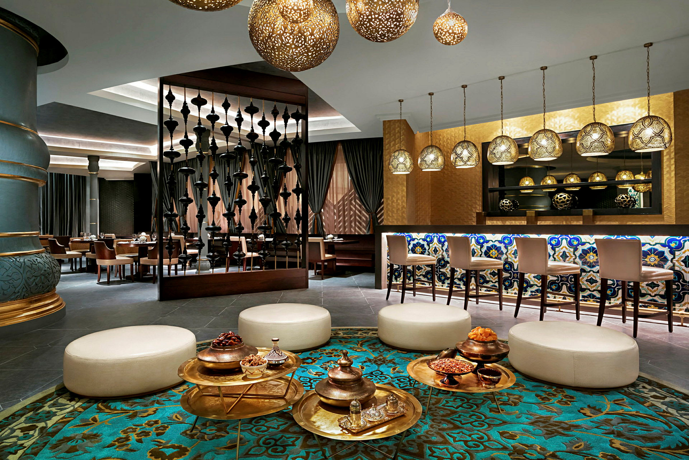 En elegant hotellobby med sittegrupper, dekorative lamper og en bar med mosaikkdetaljer. (AI-generert tekst)