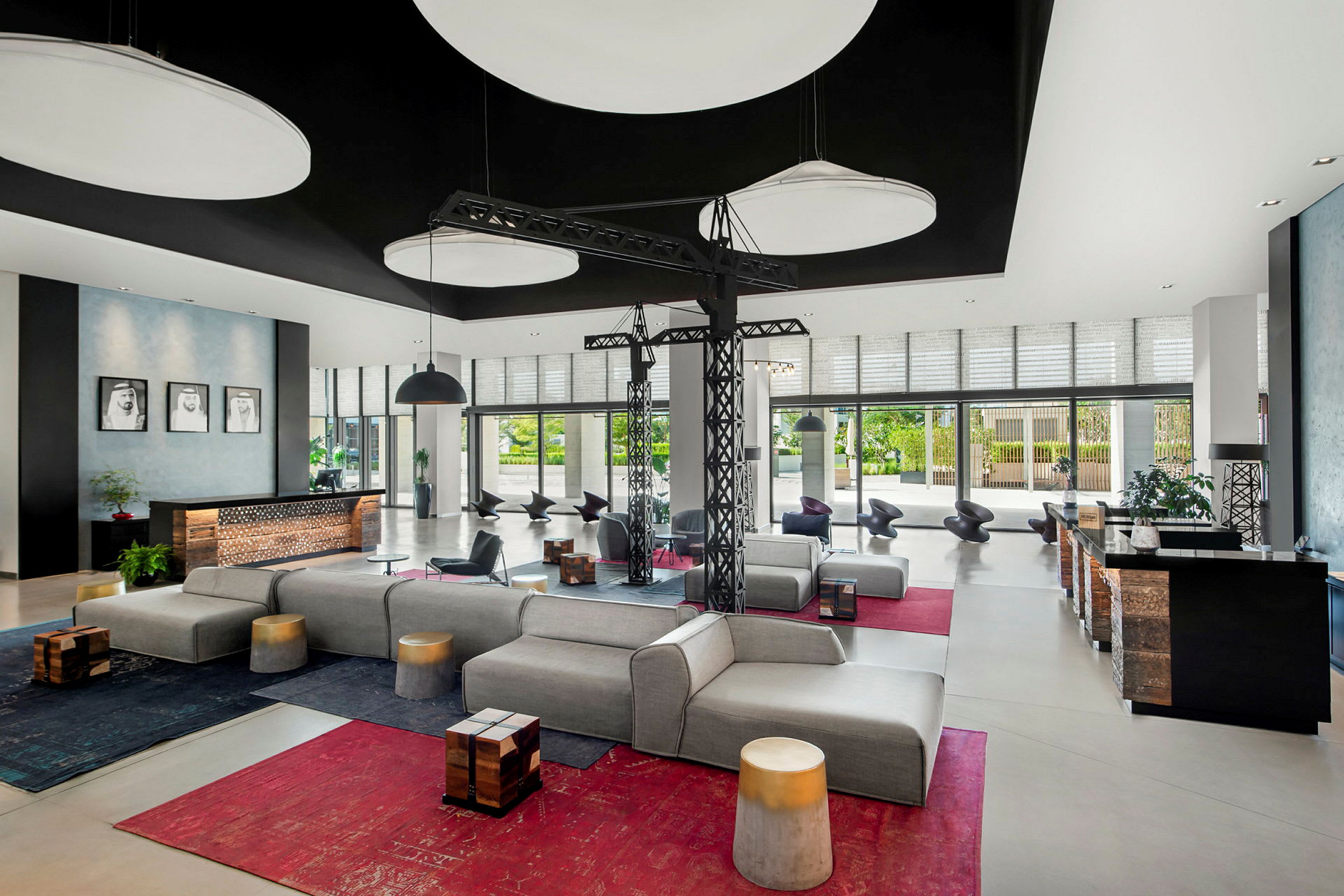 En moderne hotellobby med komfortable sittemøbler, designerbelysning og store vinduer som slipper inn naturlig lys. (AI-generert tekst)