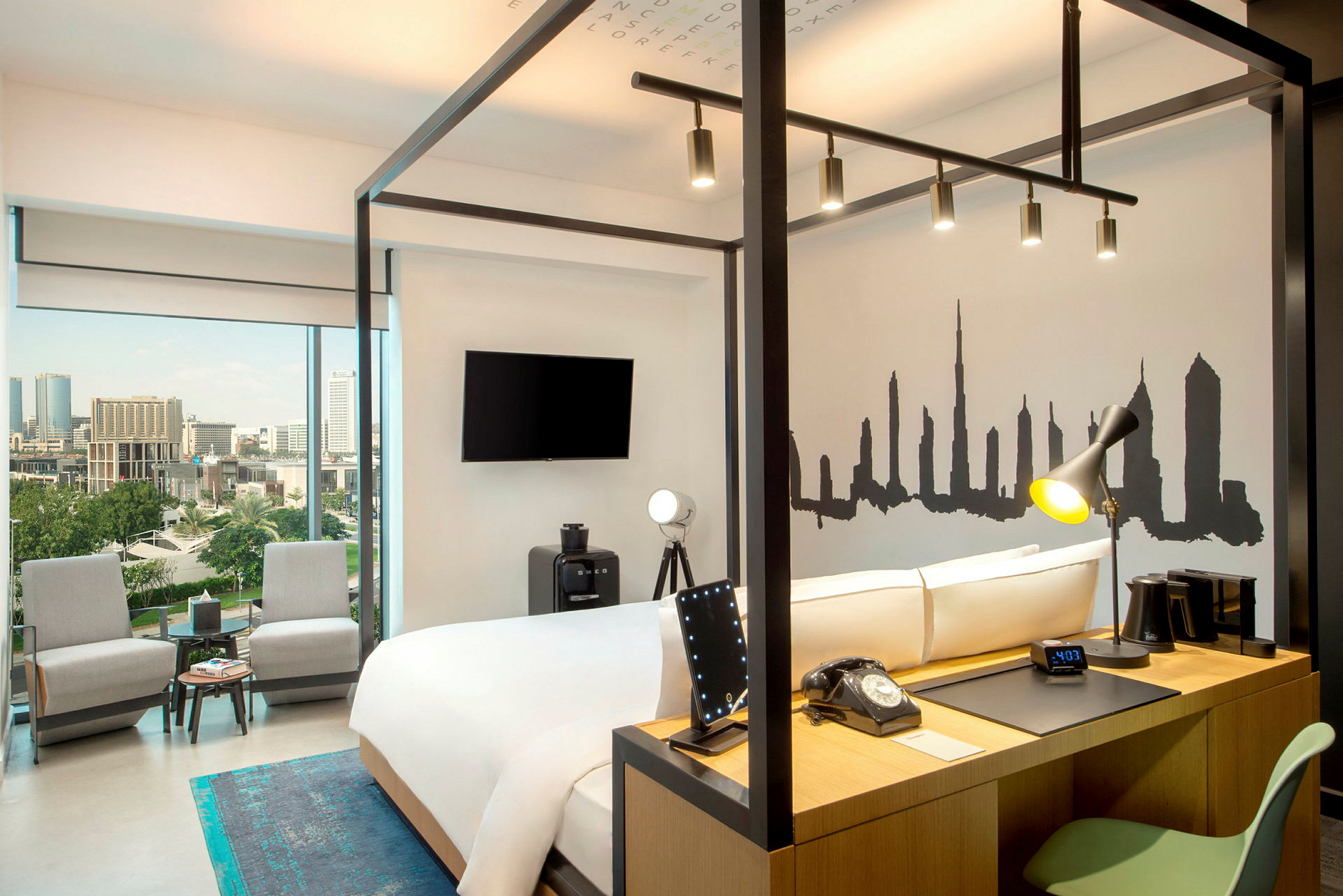 Et moderne hotellrom med en dobbeltseng, skrivebord og panoramautsikt over en by. (AI-generert tekst)