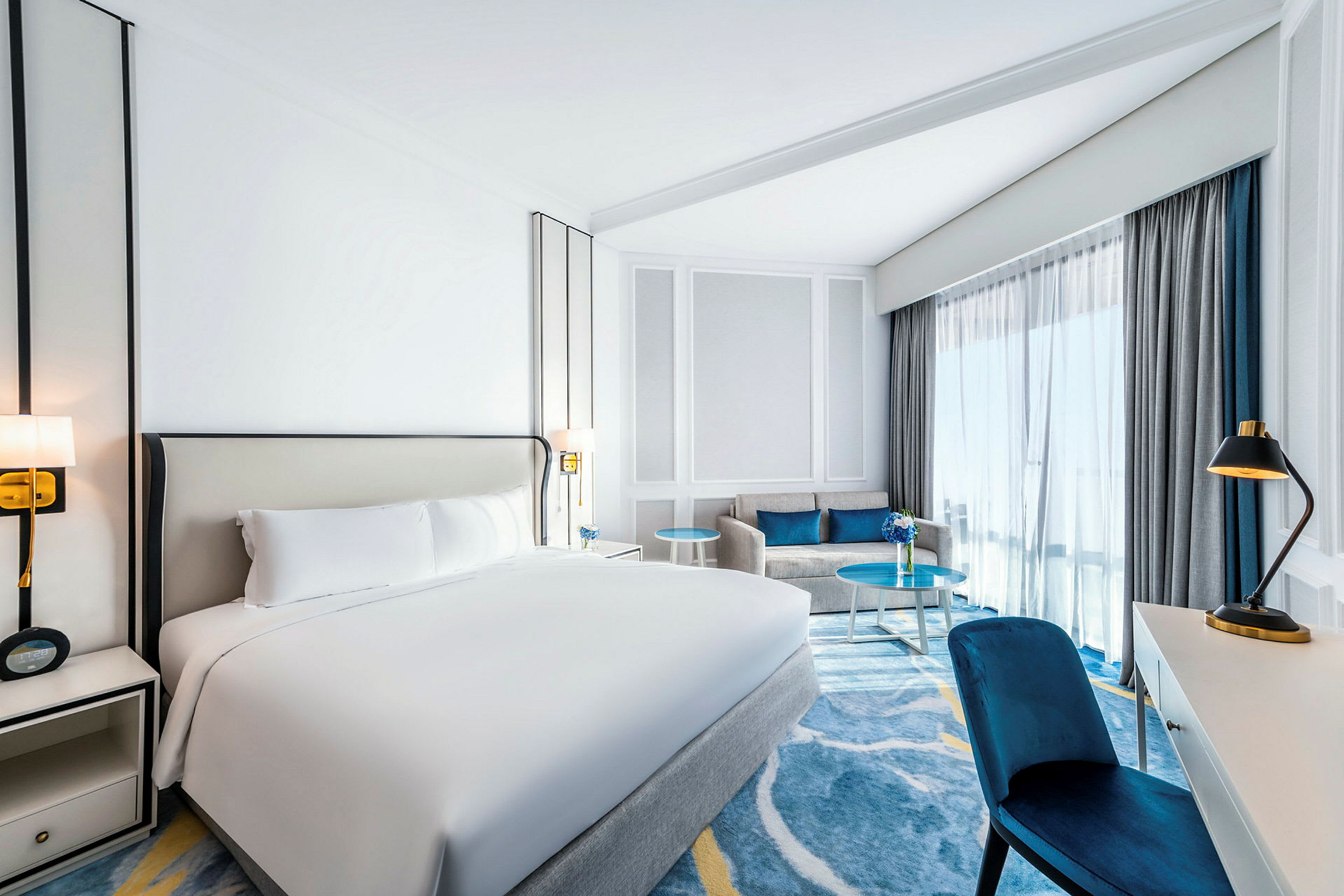 Et hotellrom med en dobbeltseng, en sofa og et skrivebord. (AI-generert tekst)