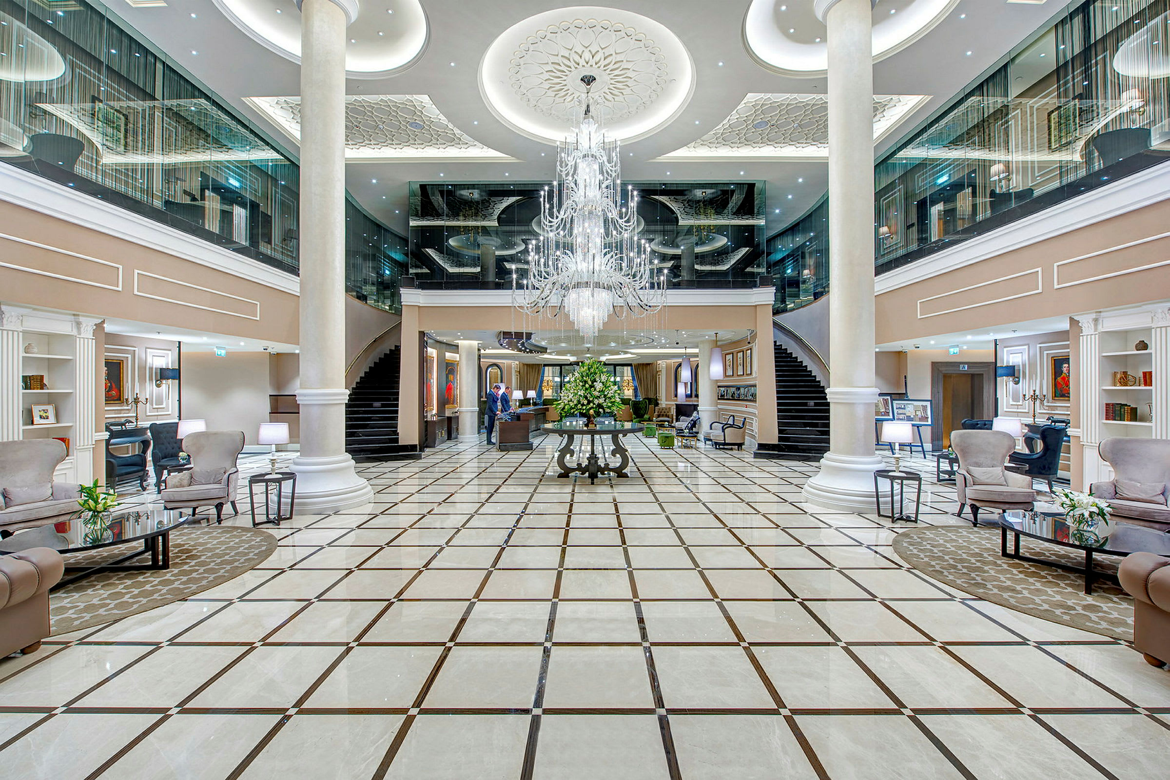 Innvendig av et elegant hotell med romslig lobby, marmorgulv og en sentrert lysekrone. (AI-generert tekst)
