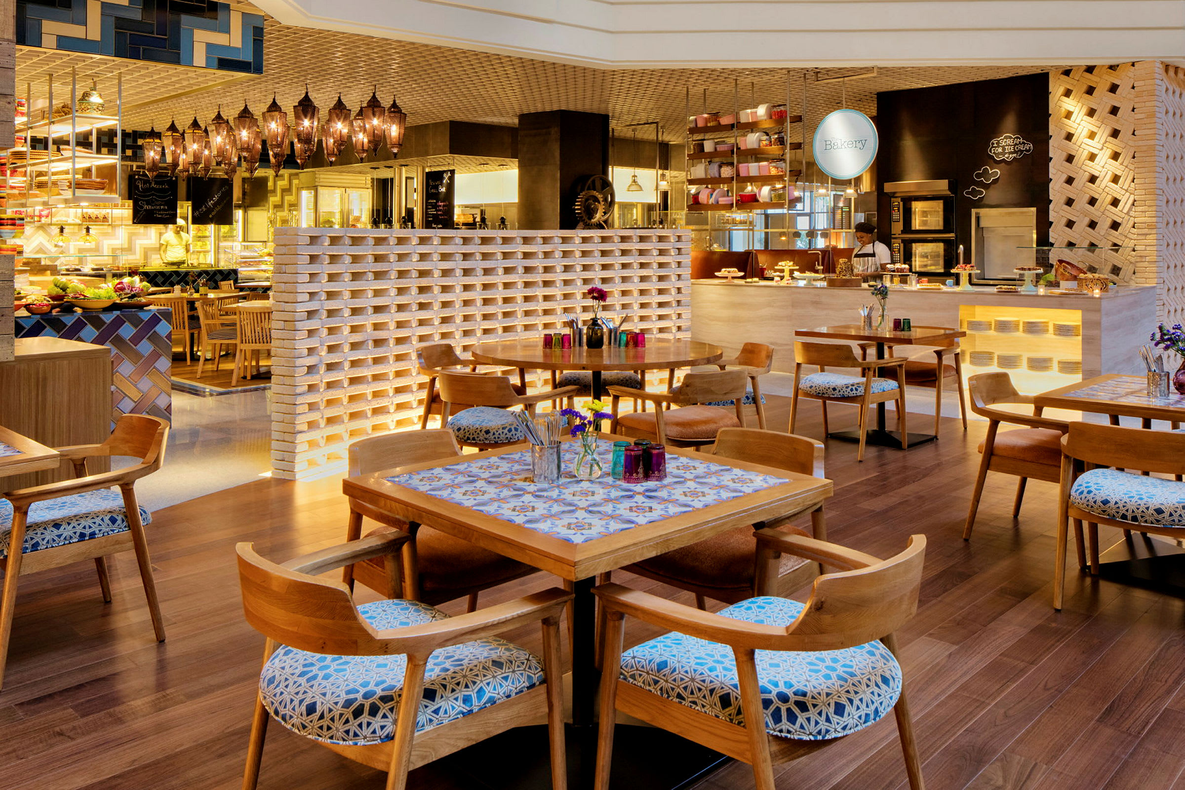 Interiør av en sjarmerende restaurant med trebord og stoler, dekorert med blomster og fargerike detaljer. (AI-generert tekst)