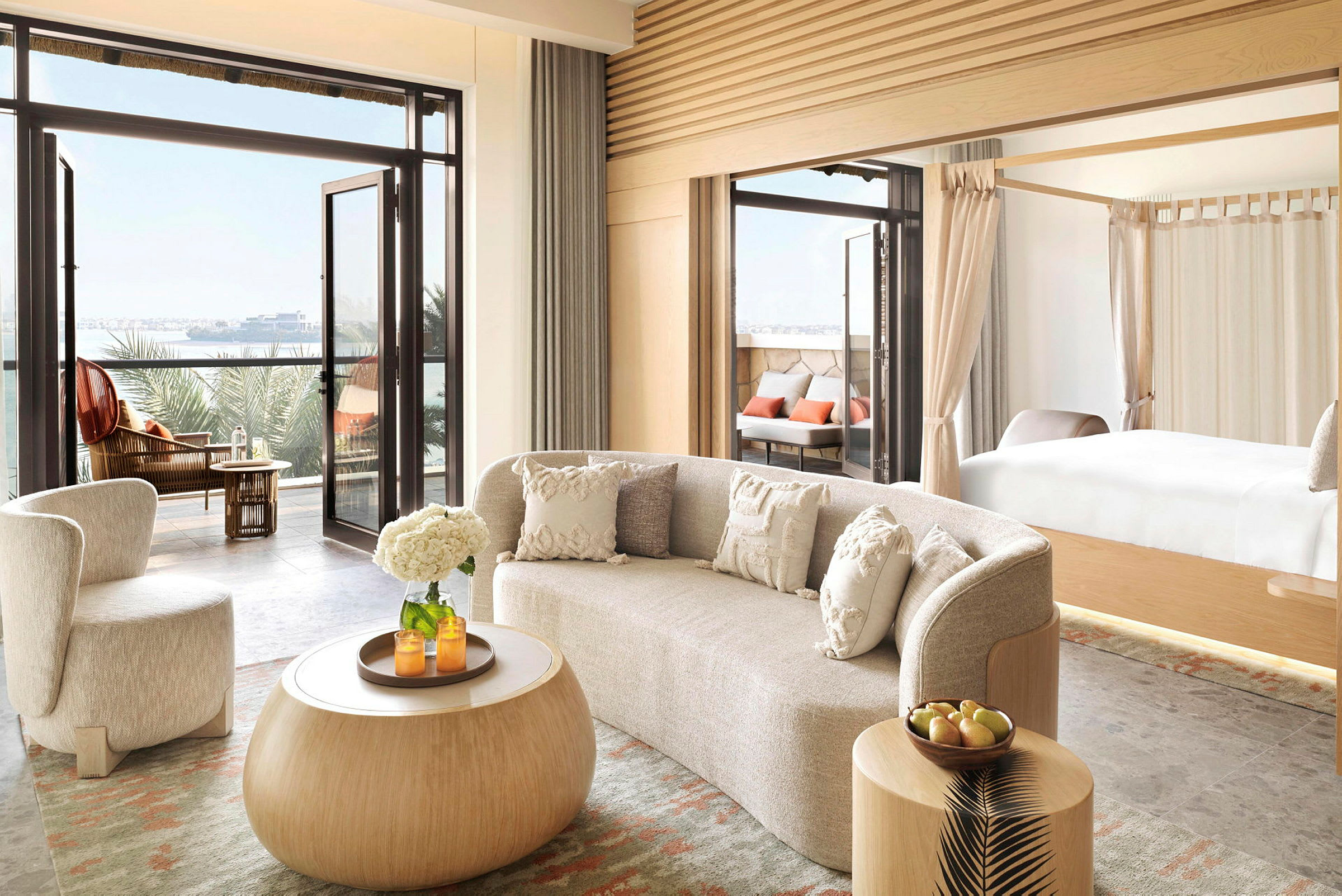 Moderne innredet hotellsuite med utgang til balkong og utsikt over havet. (AI-generert tekst)
