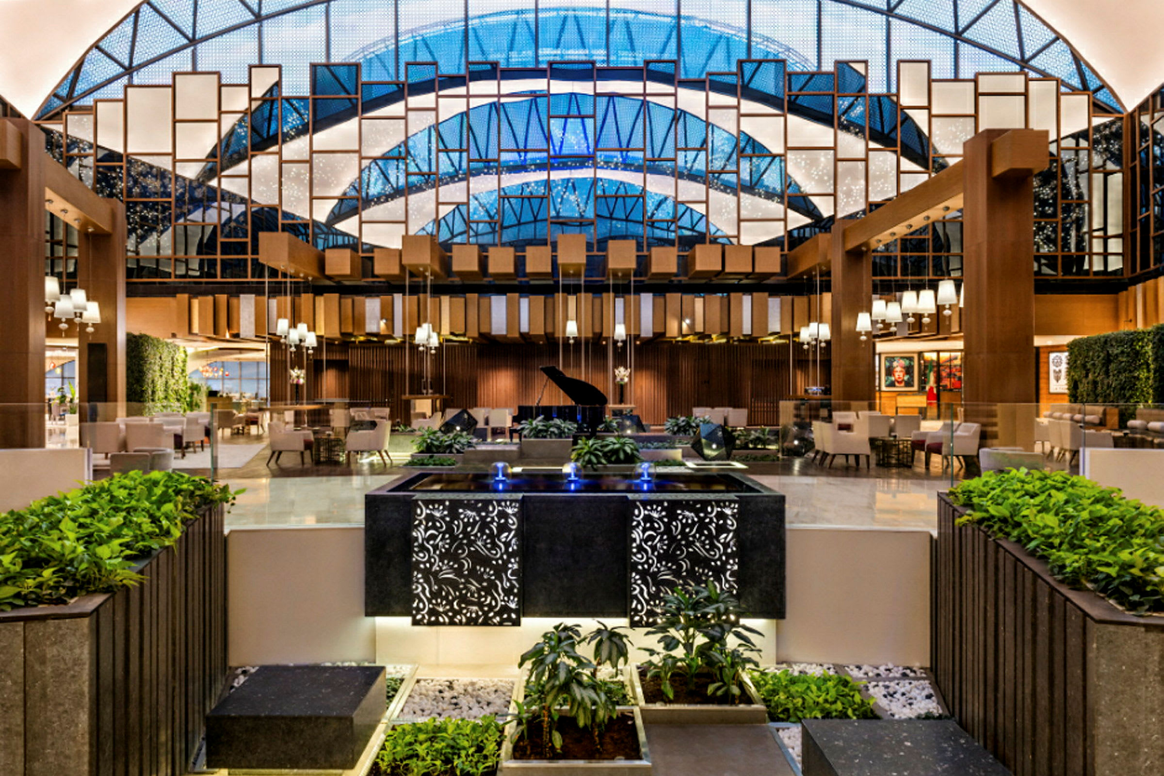 Interiør av en elegant hotellobby med et flygel, sitteplasser og dekorativ vegetasjon. (AI-generert tekst)
