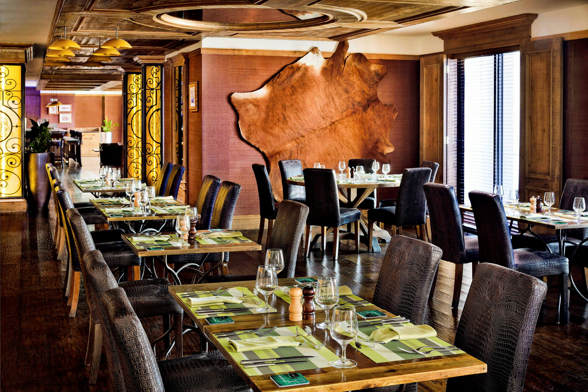 En elegant restaurant med dekkede bord, komfortable stoler og smakfull innredning. (AI-generert tekst)
