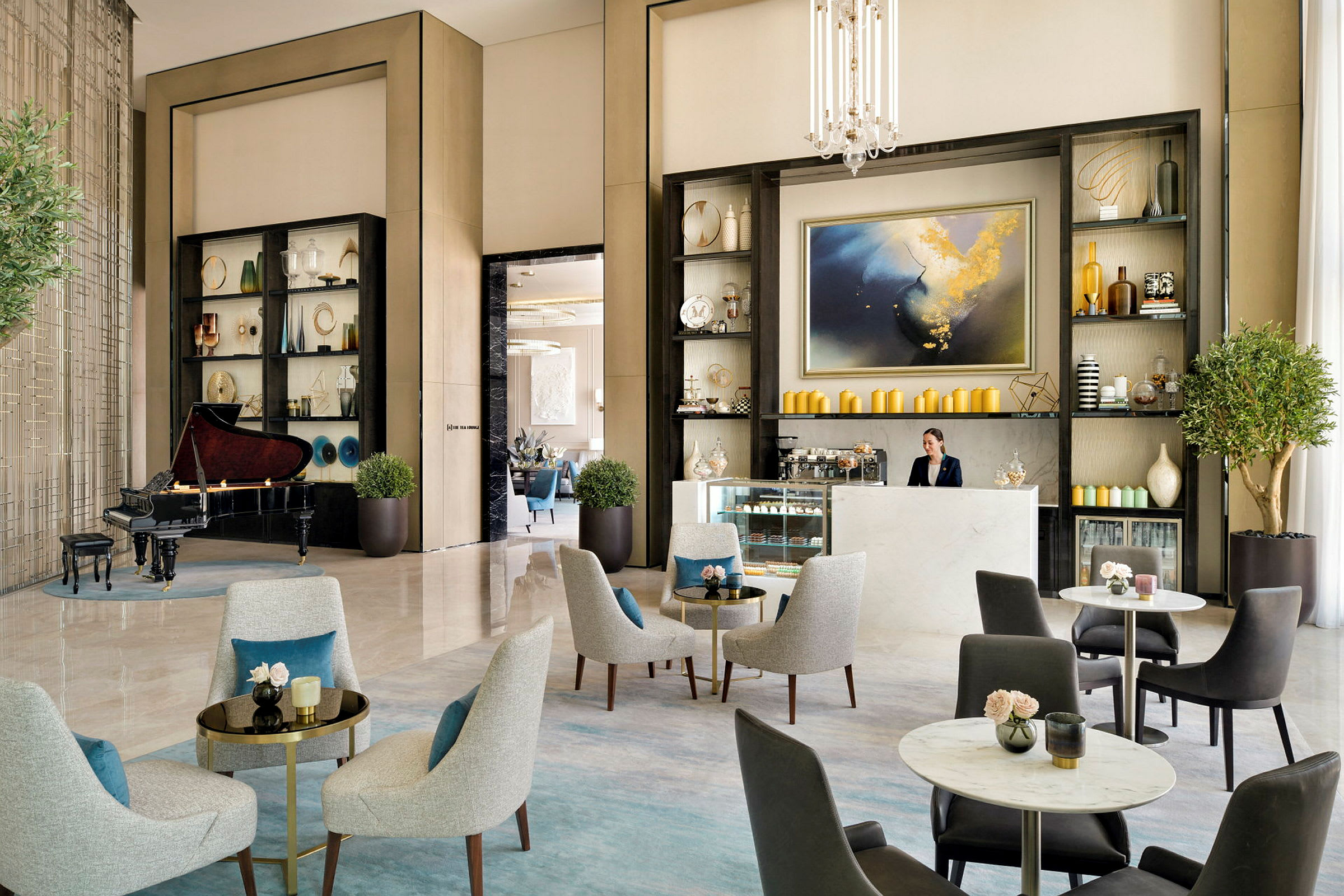 Et elegant loungeområde med sitteplasser, et piano og en resepsjon med hyller dekorert med vaser og kunstgjenstander. (AI-generert tekst)