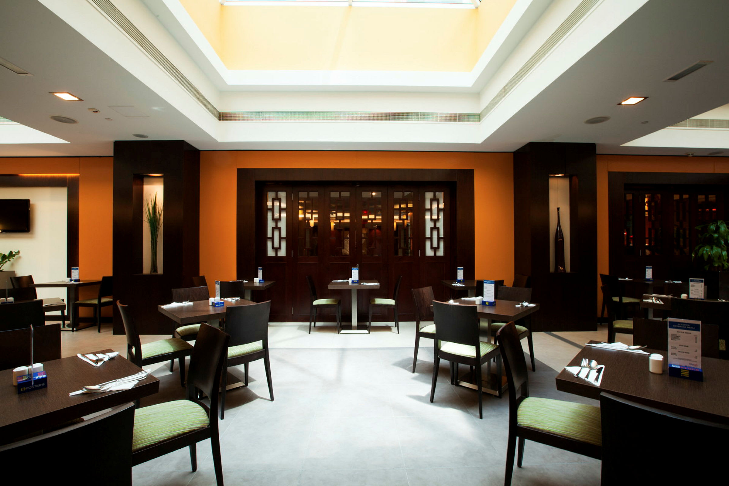 Interiør av en moderne restaurant med bord og stoler plassert rundt. (AI-generert tekst)