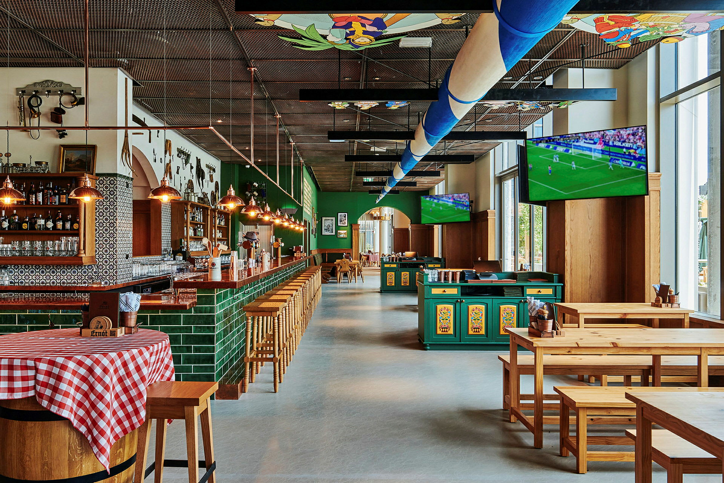 En bar og restaurant med trebord og stoler samt TV-skjermer som viser en fotballkamp. (AI-generert tekst)