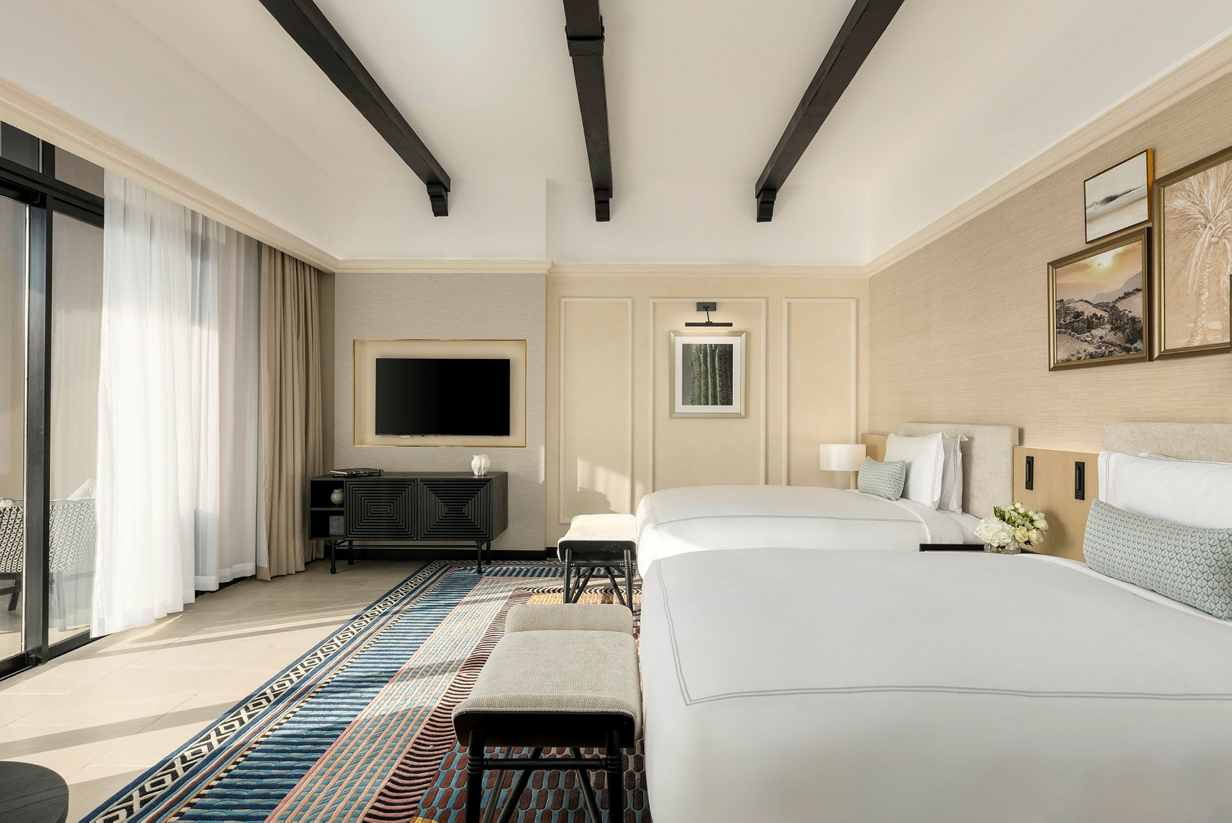 Et moderne hotellrom med to enkeltsenger, en TV på veggen og et vindu med gardiner. (AI-generert tekst)
