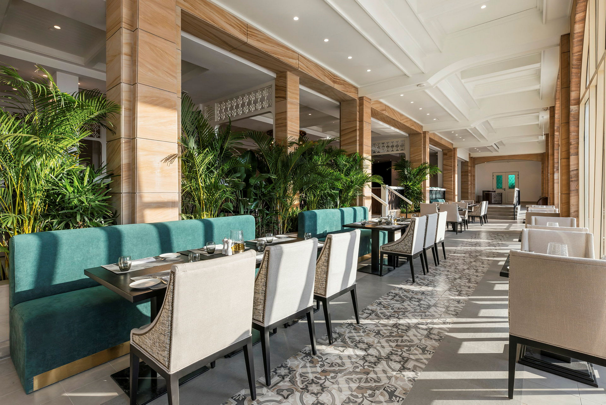 Restaurant med sitteplasser og grønne planter. (AI-generert tekst)