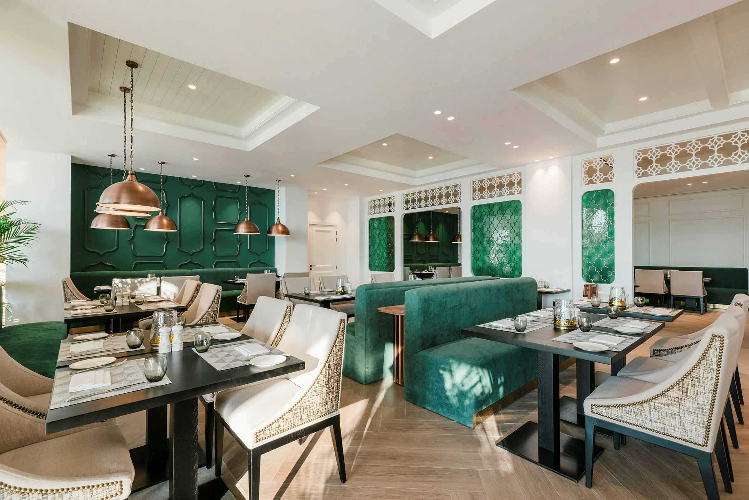 Bilde av en elegant restaurant med grønne dekorative veggpaneler og moderne møbler. (AI-generert tekst)
