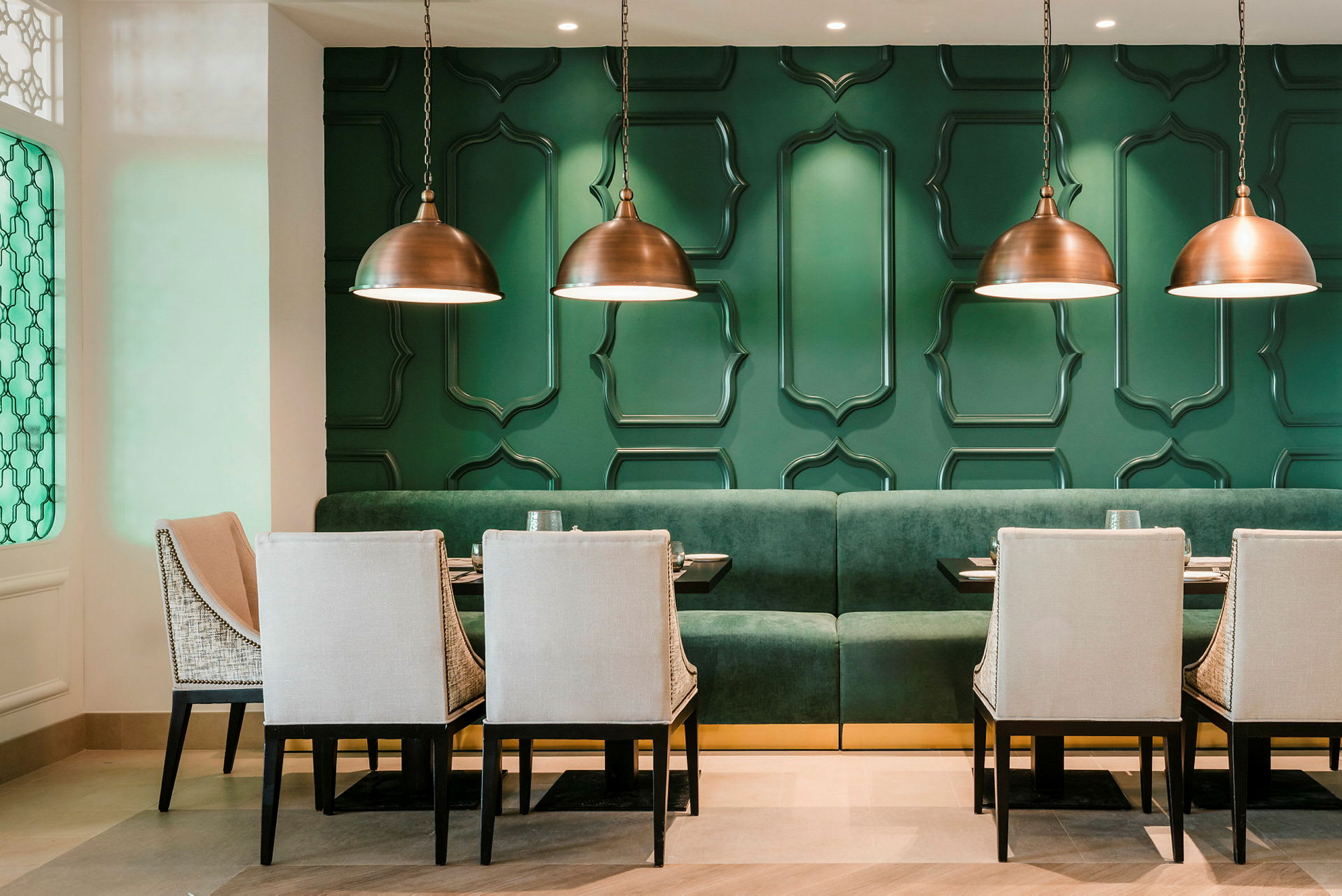 En moderne designet restaurant med grønne vegger og elegante møbler. (AI-generert tekst)