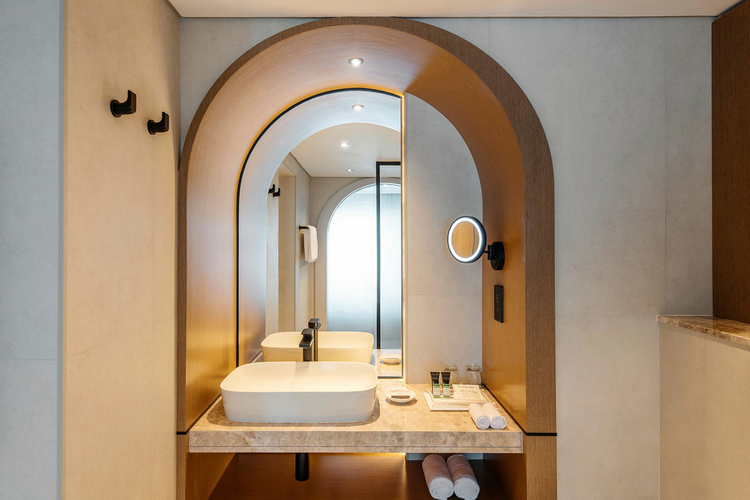 Moderne hotellbad med elegant innredning, servant og belyst speil. (AI-generert tekst)