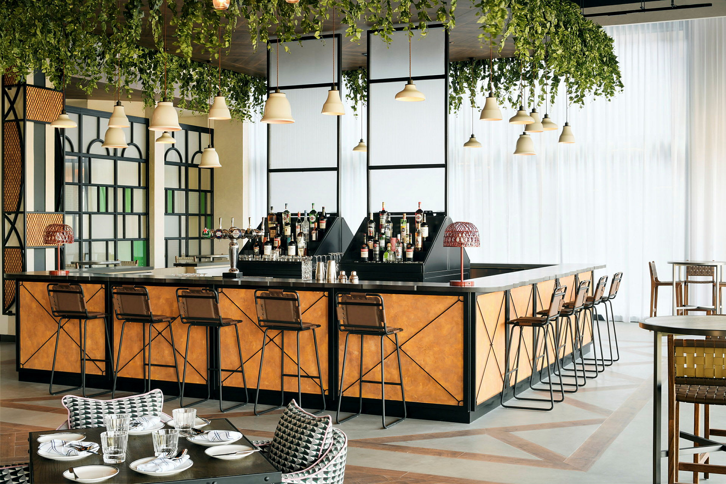 En elegant bar med barkrakker, flasker og grønne hengende planter. (AI-generert tekst)