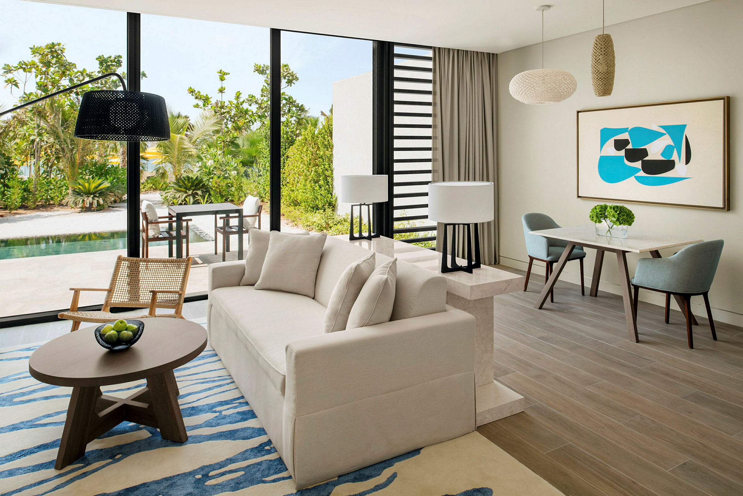 Moderne stue med stor sofa, lenestol og spisebord samt utsikt over en terrasse med grøntområde og basseng. (AI-generert tekst)