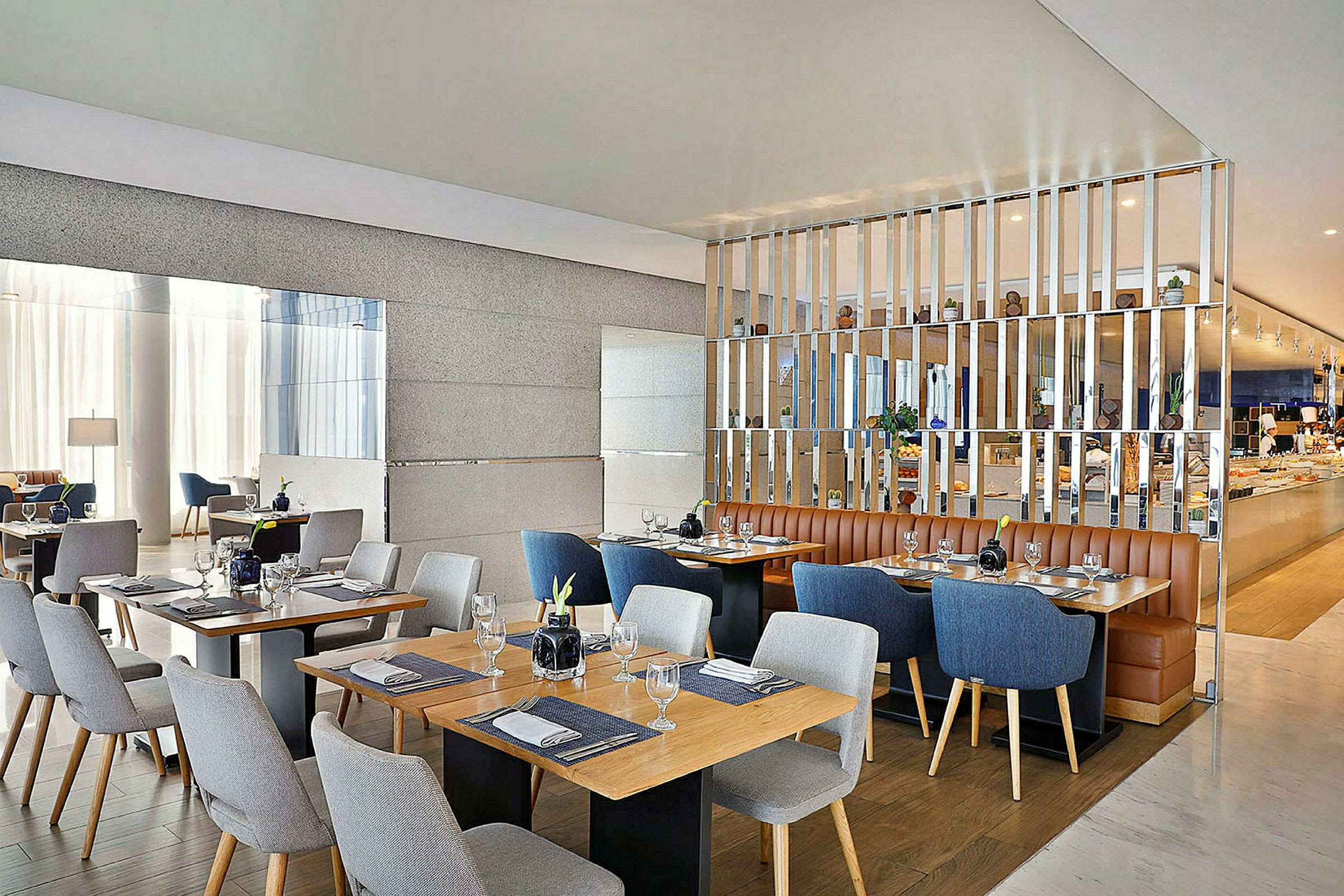 Bilde av en moderne restaurant med flere dekkede bord og stoler i forskjellige farger. Varm og elegant interiør. (AI-generert tekst)