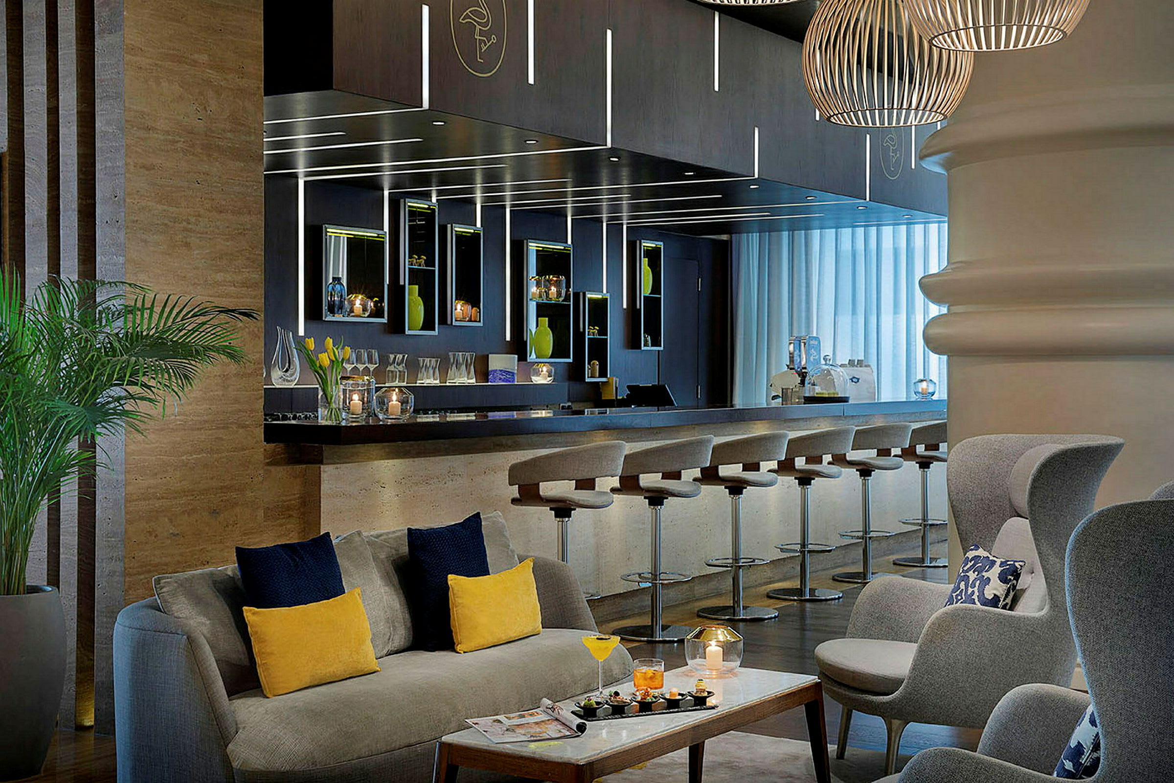 En innbydende hotellounge med en bar, noen stoler ved bardisken og komfortable sittegrupper. (AI-generert tekst)