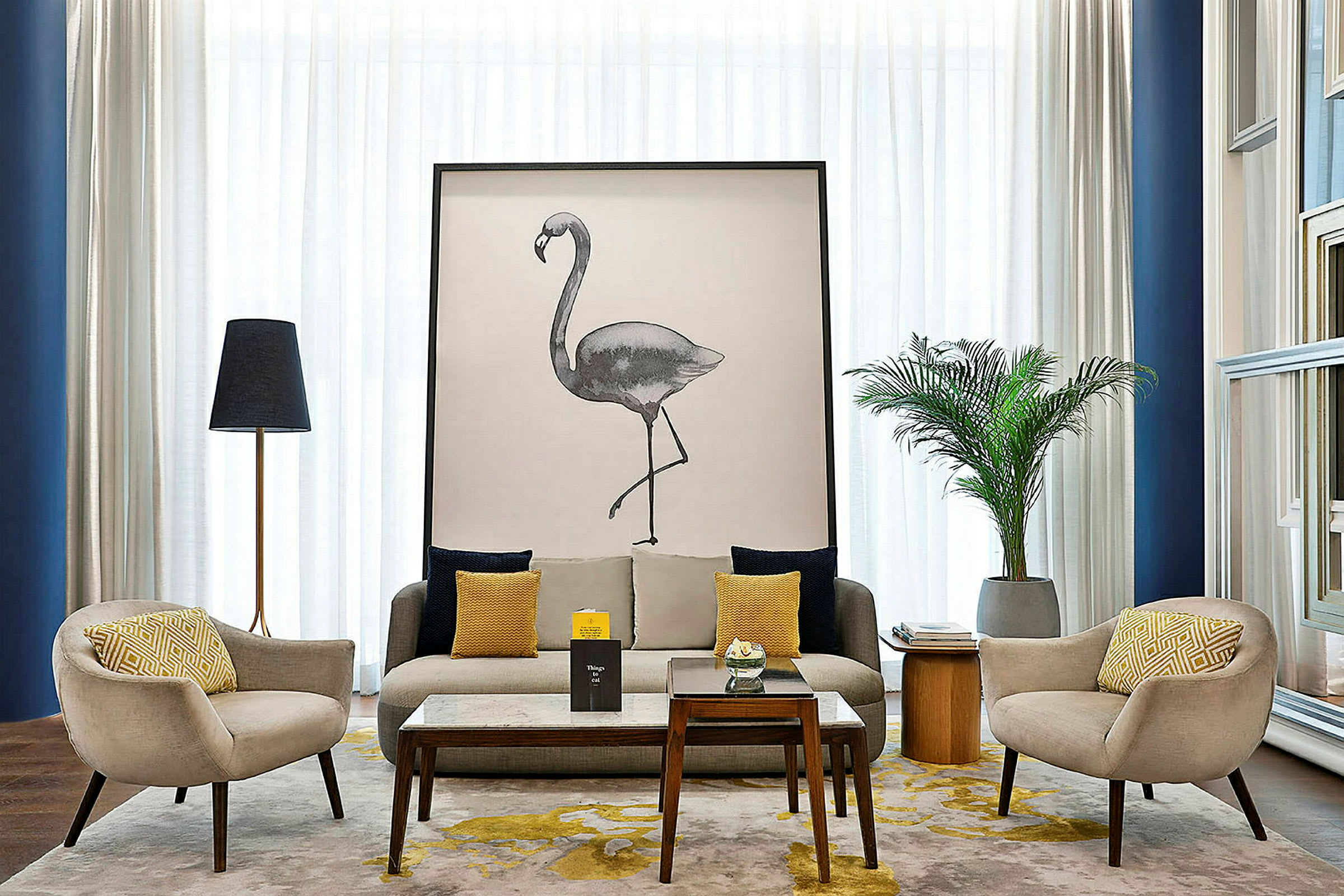 En velmøblert stue med sofaer, et stort kunstverk som viser en flamingo, dekorative planter og et bord. (AI-generert tekst)