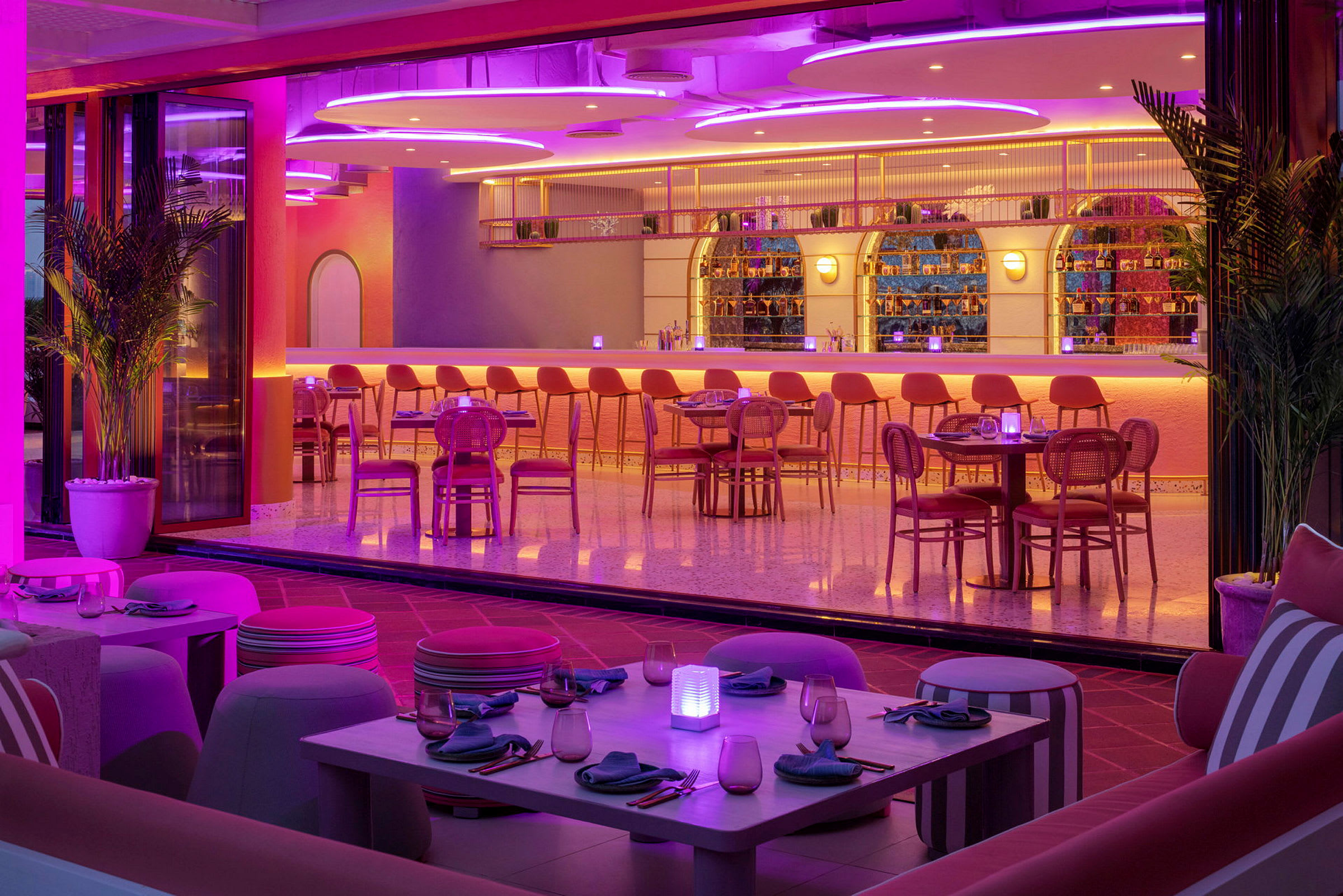En moderne bar og restaurant med fargerik belysning og stilig interiør. (AI-generert tekst)