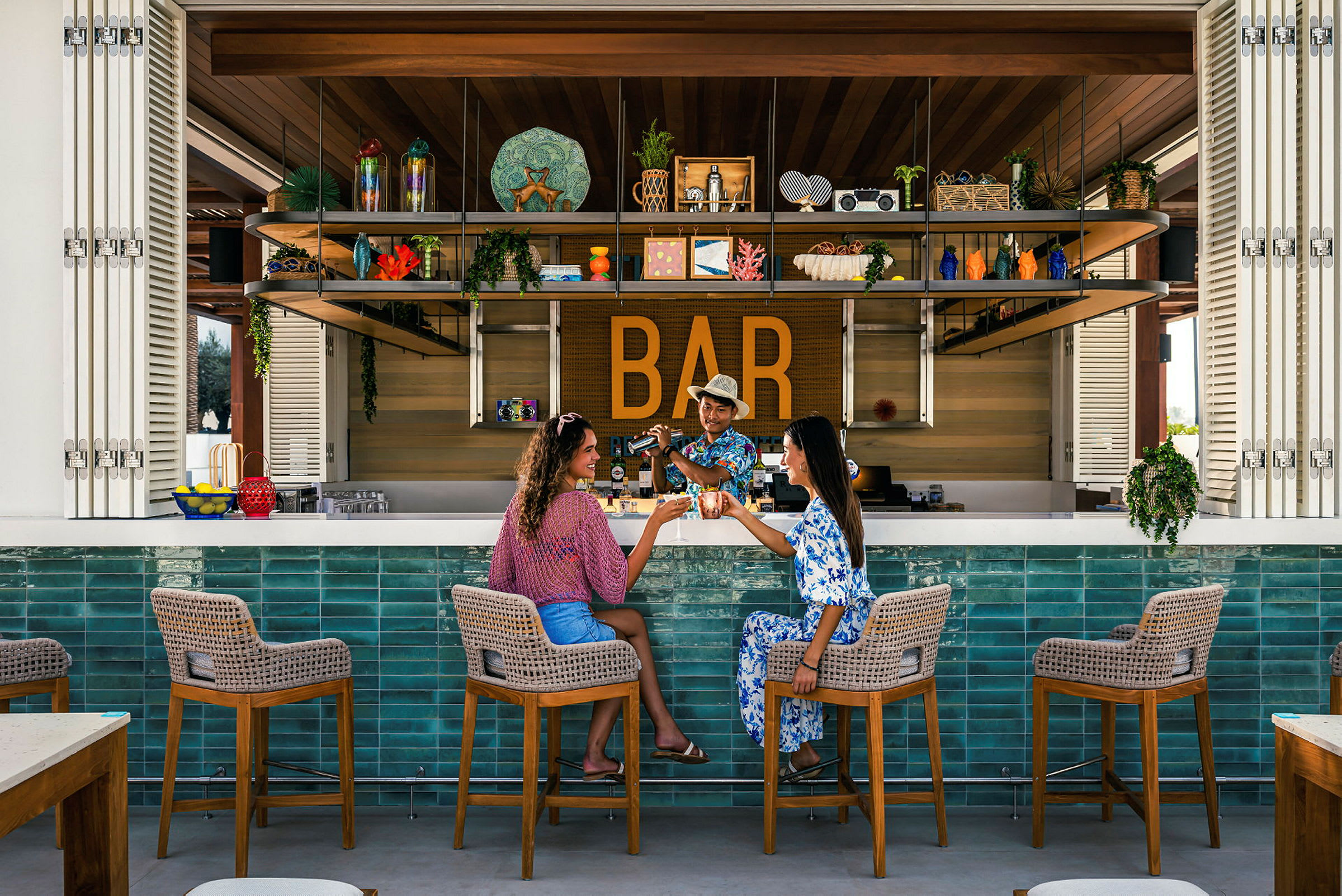 To personer sitter ved en bar med fargerik innredning. (AI-generert tekst)
