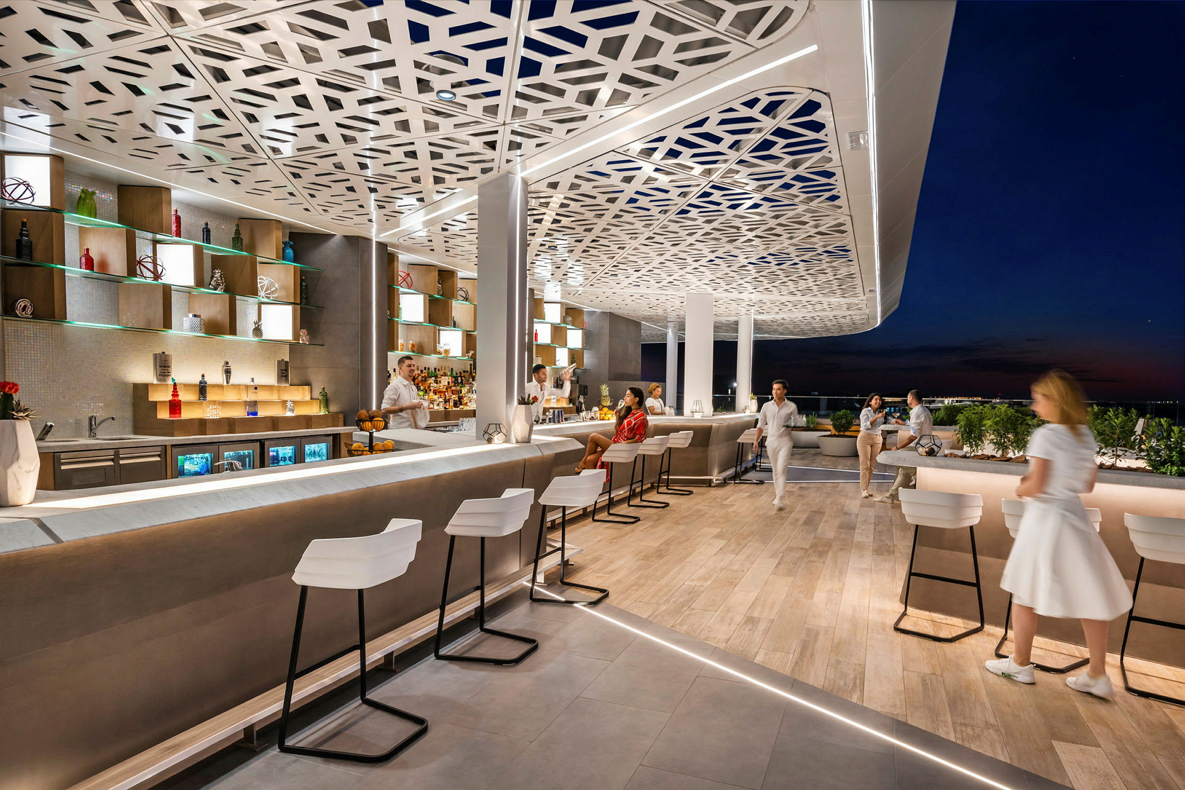 En moderne takterrasse med elegante barkrakker, en opplyst bardisk og dekorativt tak. Personer nyter en kveldsstemning. (AI-generert tekst)