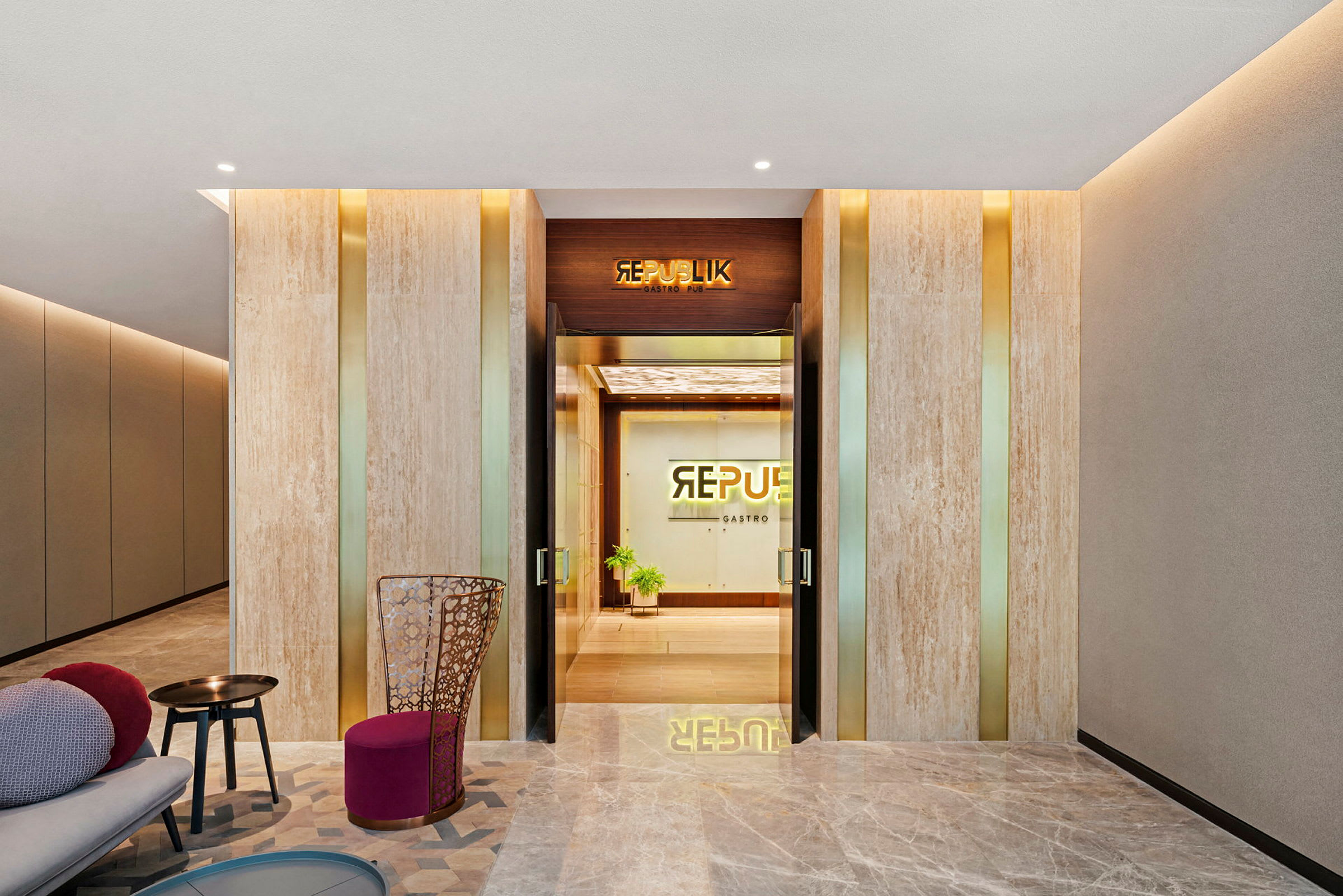 Lobby med moderne interiør, inkluderer sitteplasser og inngang til Republik Gastro Pub. (AI-generert tekst)