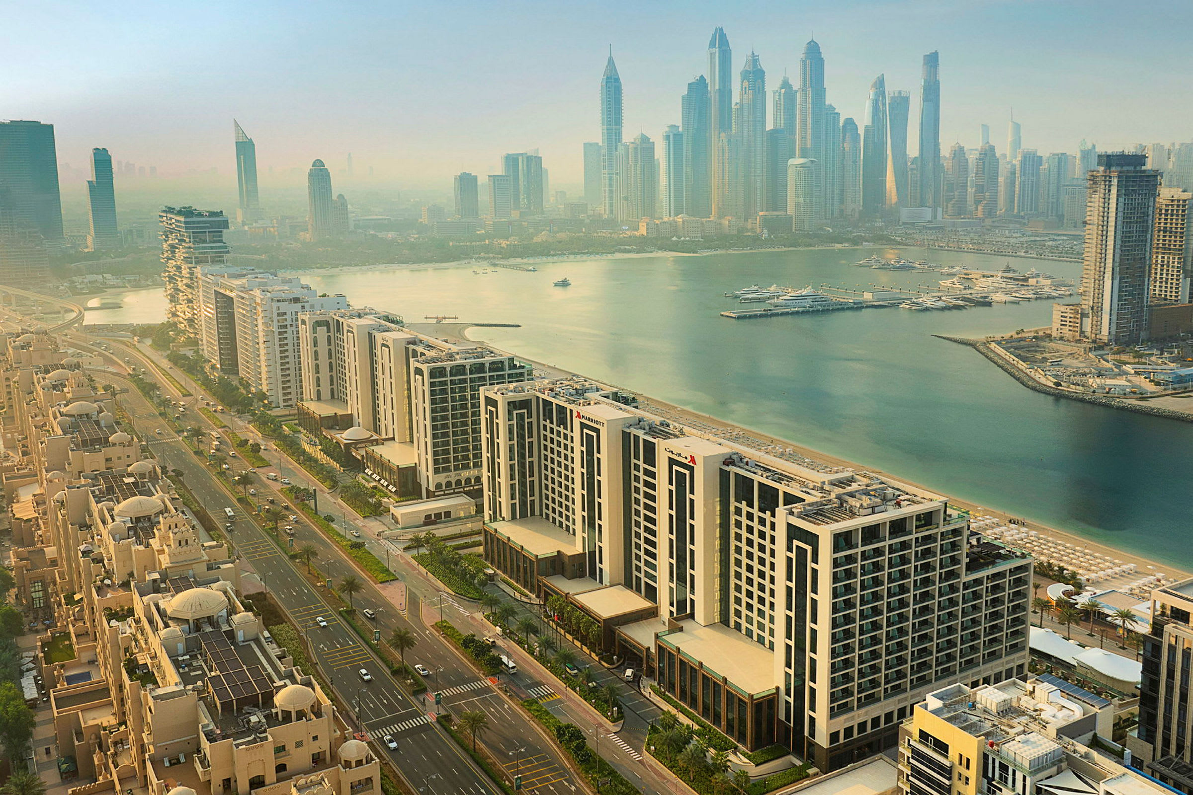 Luftig utsikt over Dubai Marina med moderne høyhus, boligområder og småbåthavn ved vannet. (AI-generert tekst)