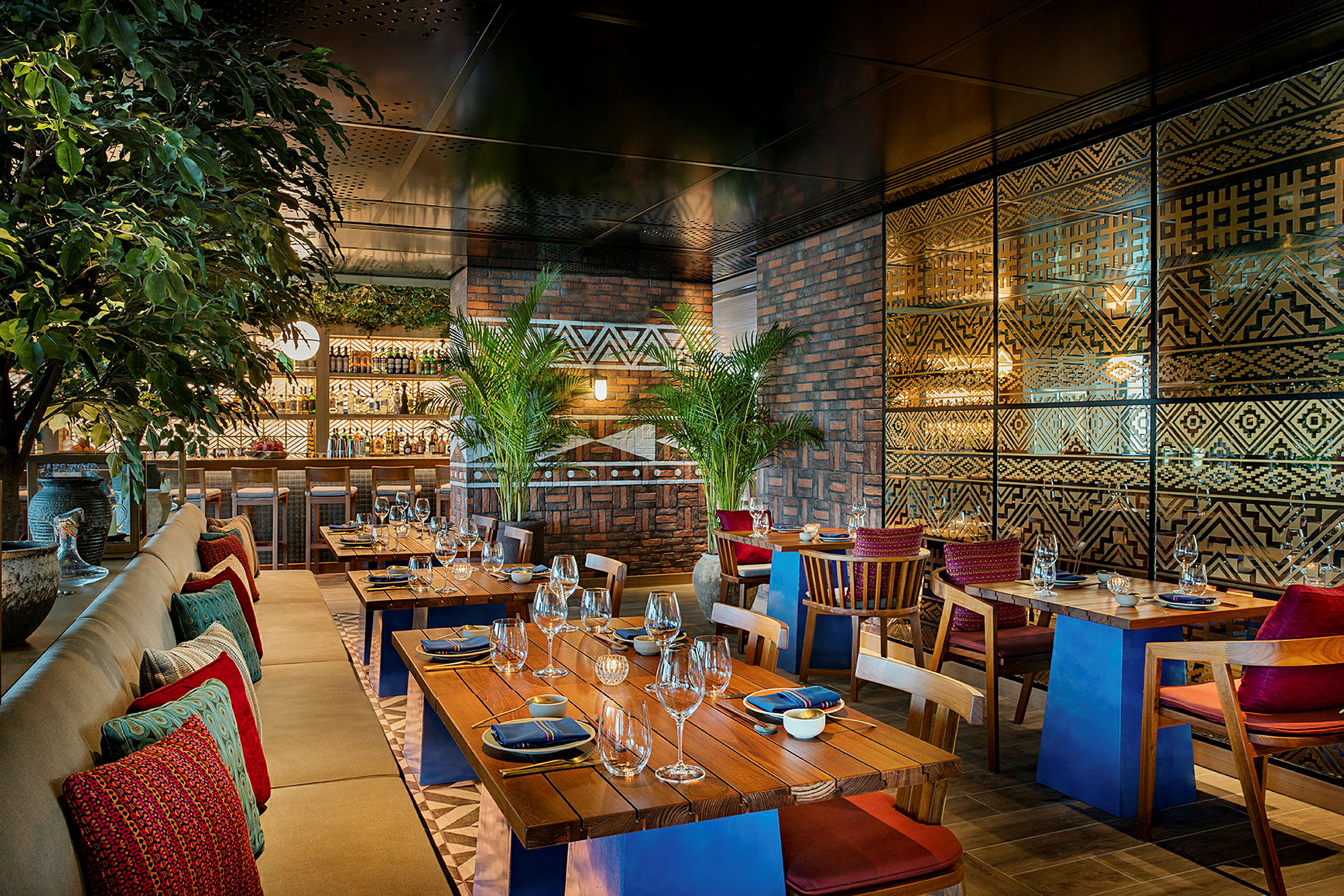 Interiør av en restaurant med trebord, polstrede stoler og dekorativ veggdesign. (AI-generert tekst)