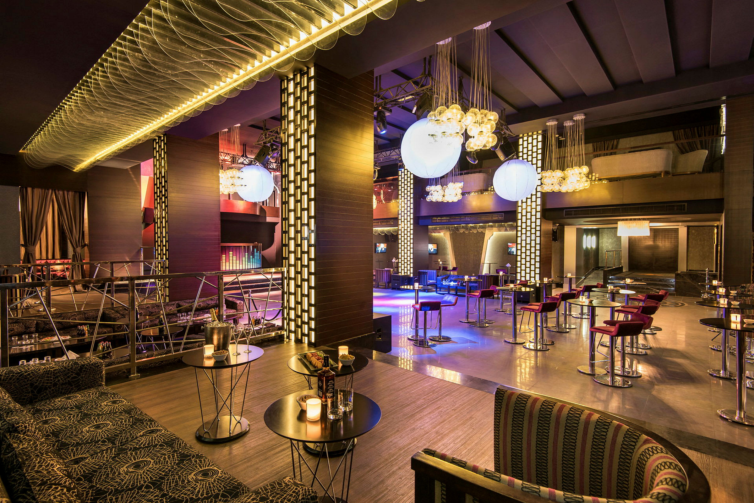 En moderne restaurant med bord og stoler, samt dekorative lysoppheng. (AI-generert tekst)