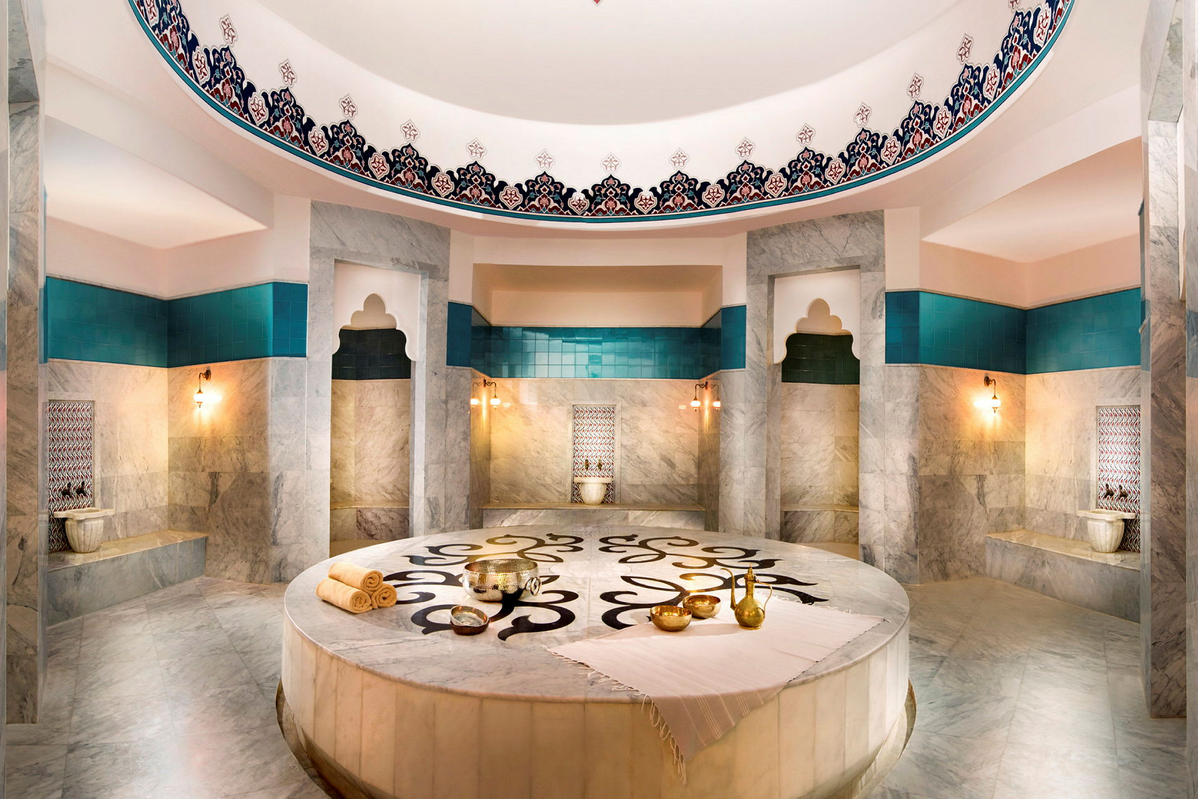Et rom i en hamam med marmorovertflater, turkise detaljer og dekorasjoner. (AI-generert tekst)