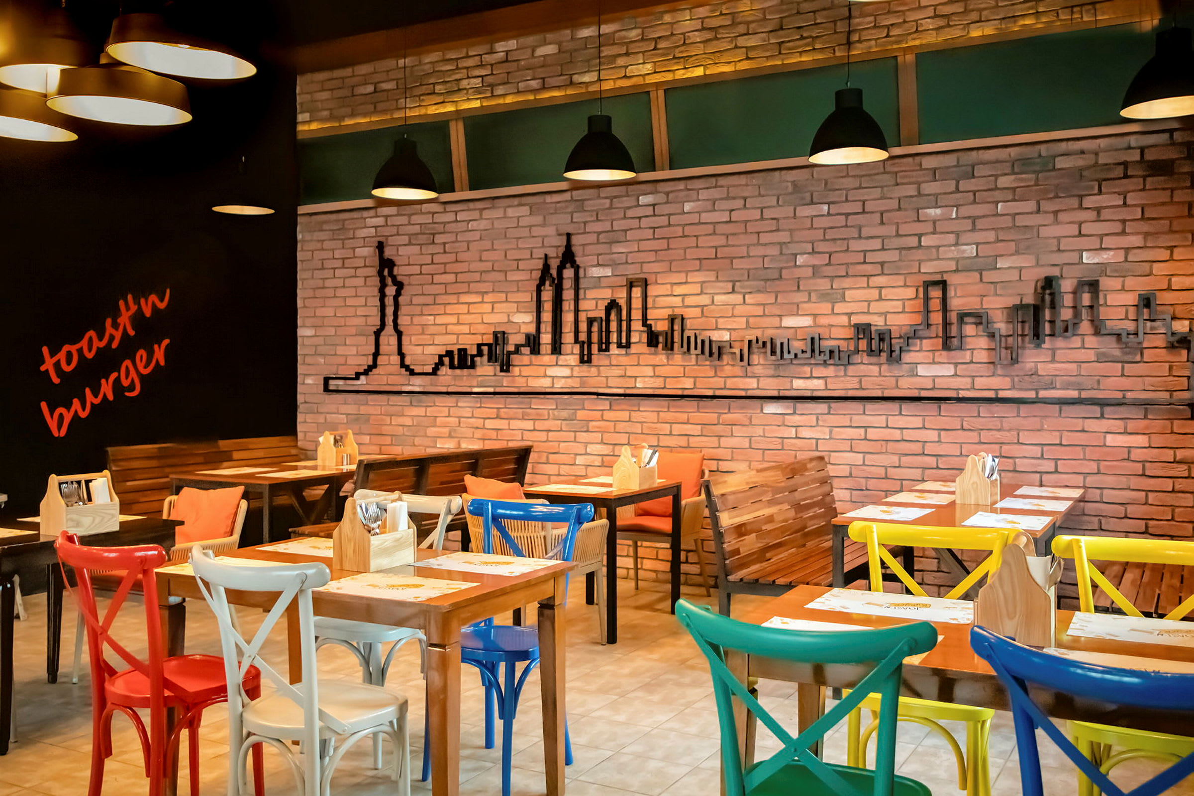 Tom restaurant med fargerike stoler, murvegg og silhuett av New York som dekorasjon. (AI-generert tekst)