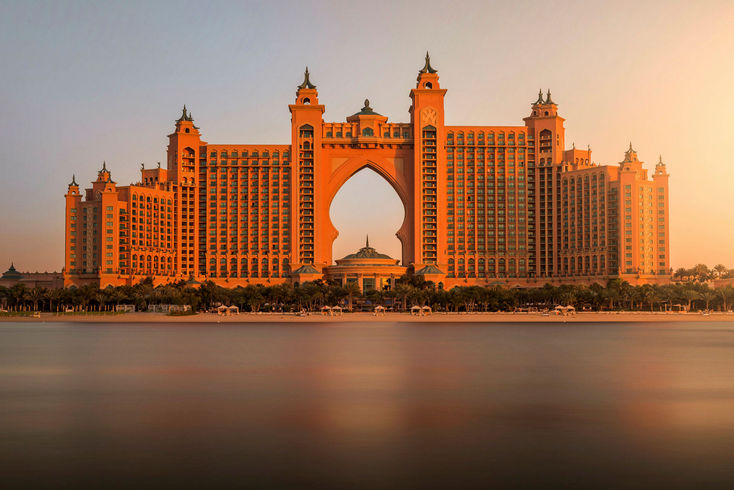 Et stort hotell med arabiske arkitektoniske detaljer ved solnedgang. (AI-generert tekst)