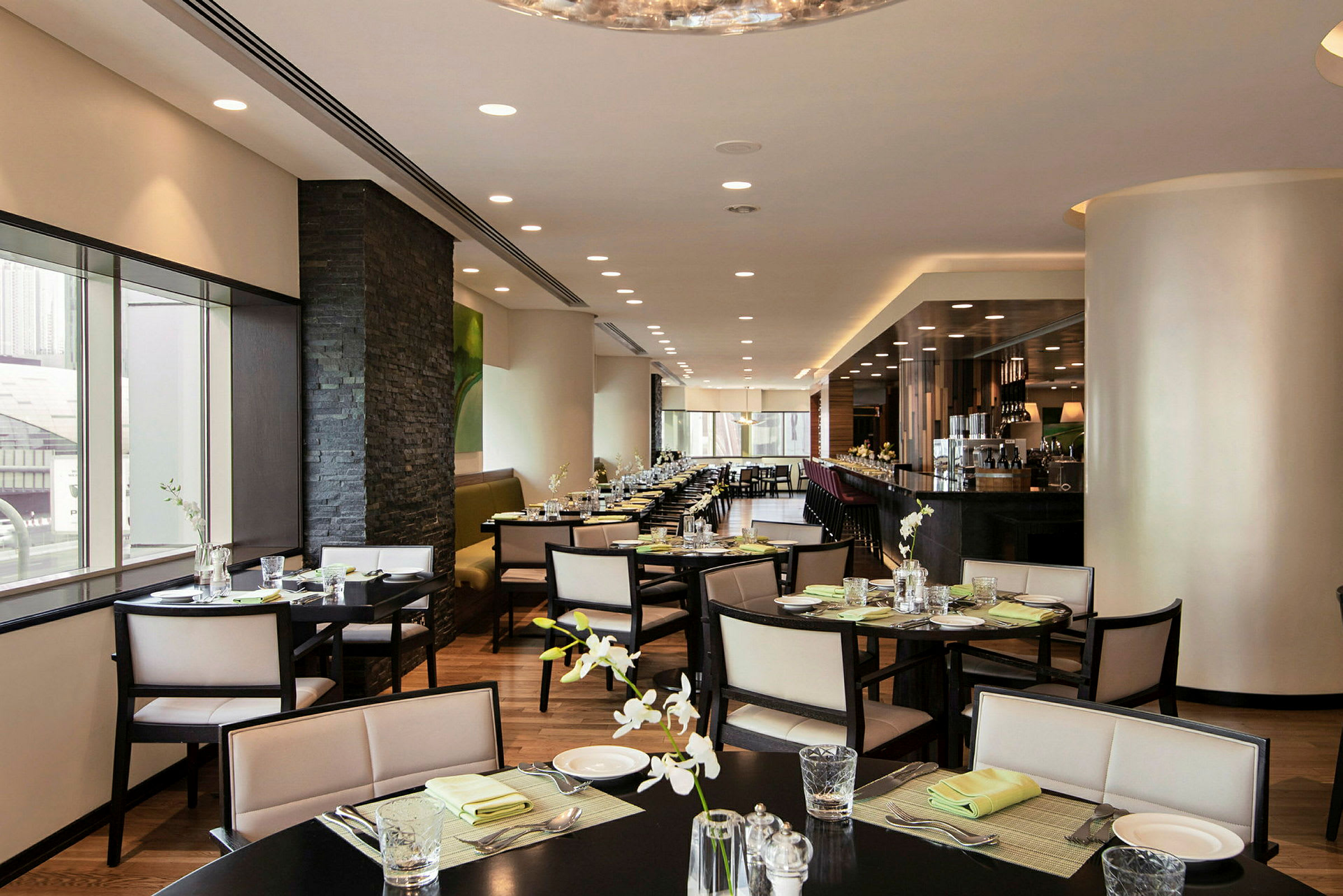 Restaurant med moderne innredning, elegante sittegrupper og lys borddekking. (AI-generert tekst)