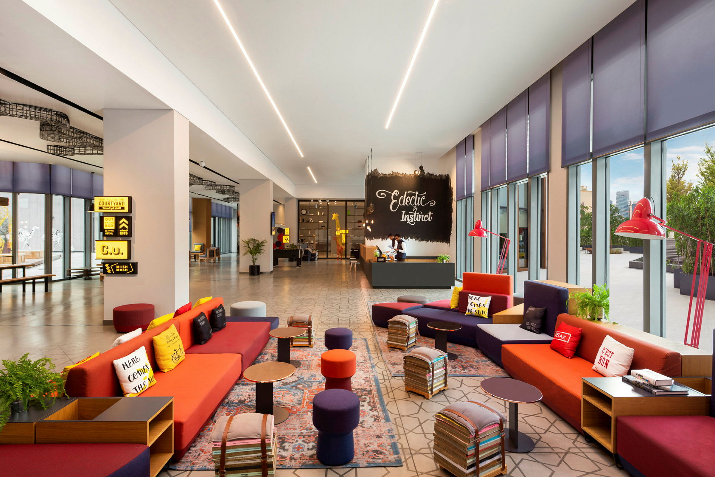 En moderne og fargerik hotellobby med sofaer og små bord. Store vinduer gir naturlig lys. (AI-generert tekst)