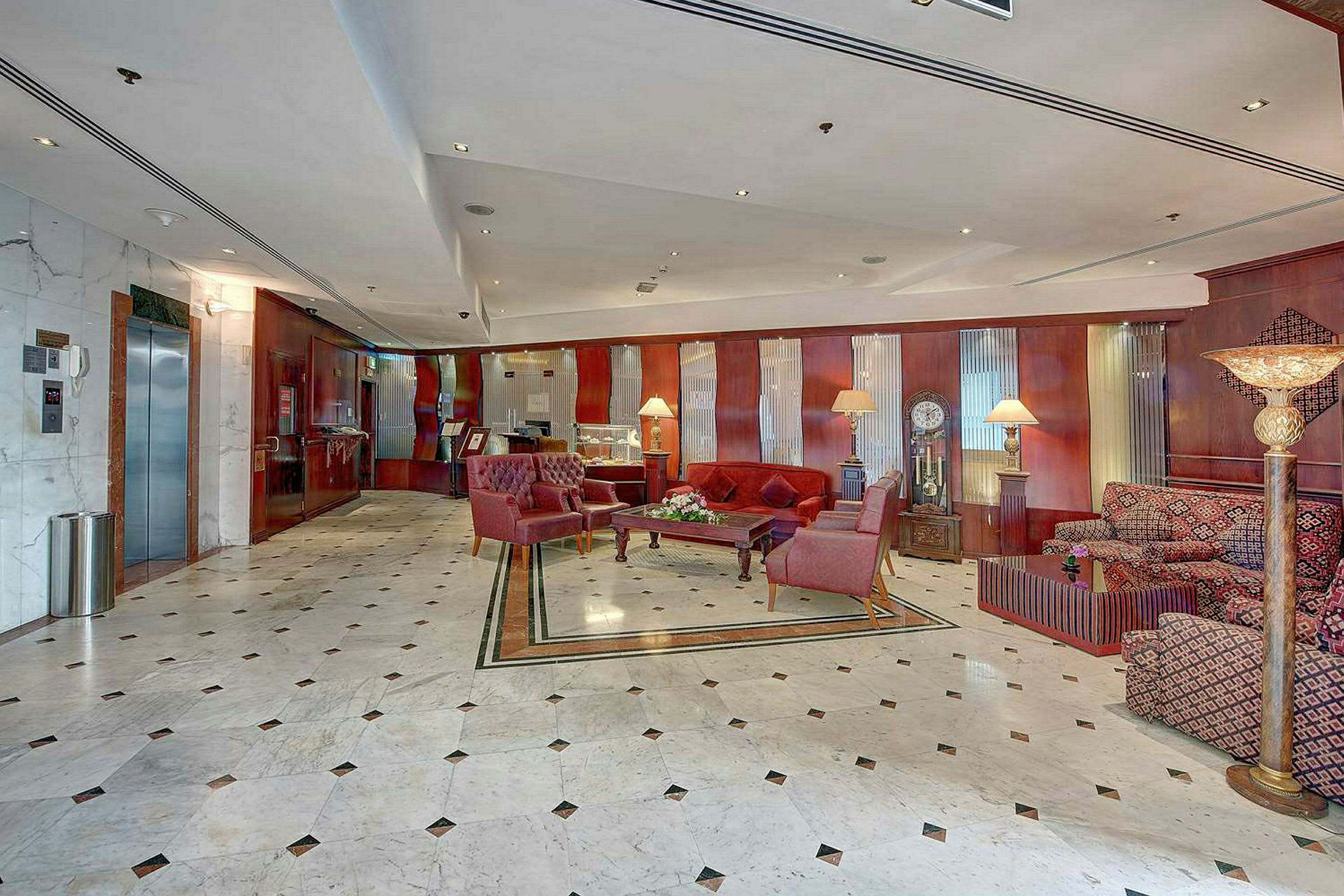 Et romslig hotellobby med marmor gulv og møbler med komfortable lenestoler og sofaer. (AI-generert tekst)