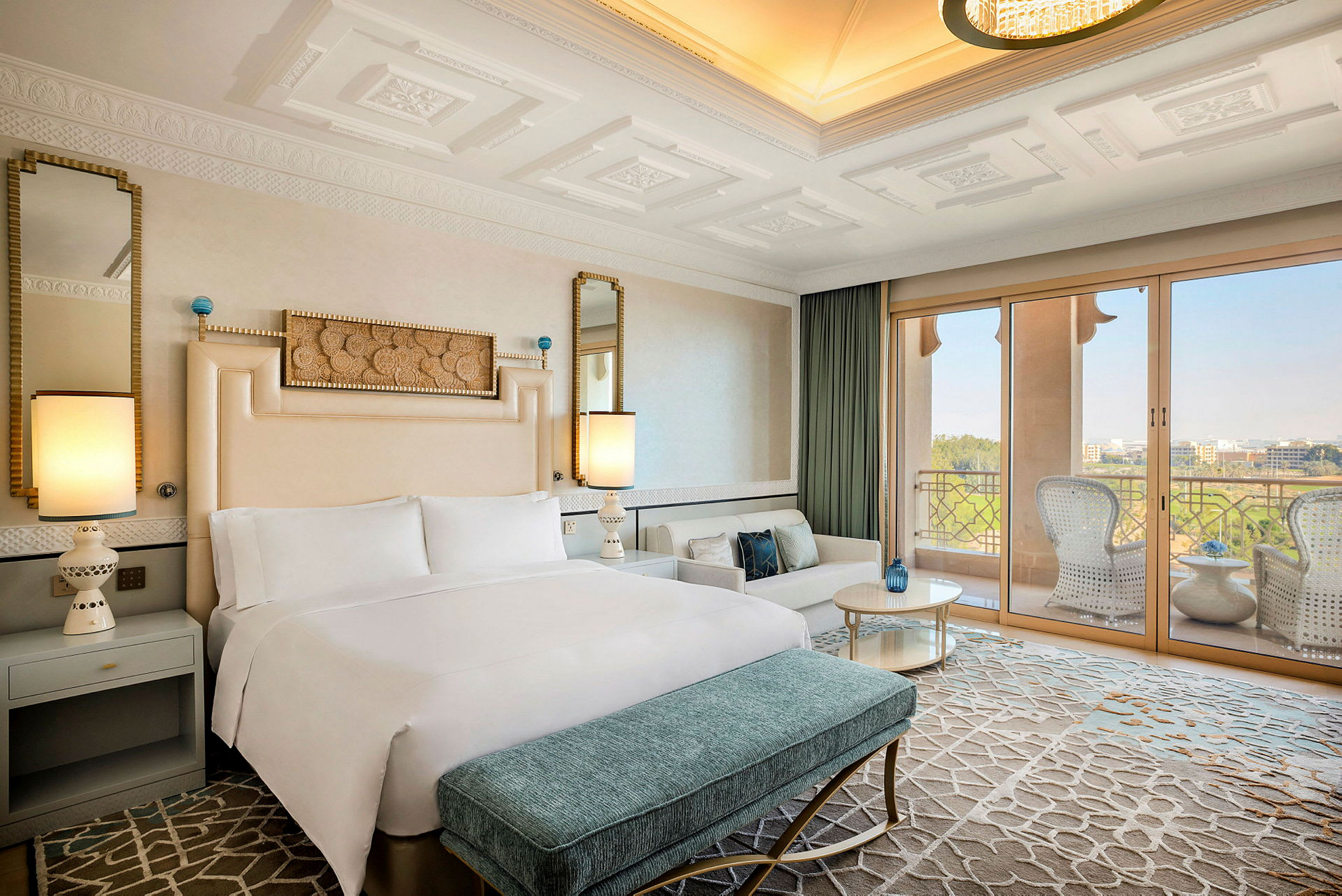 Et elegant hotellrom med en stor dobbeltseng, sitteområde og en balkong med utsikt over landskapet. (AI-generert tekst)