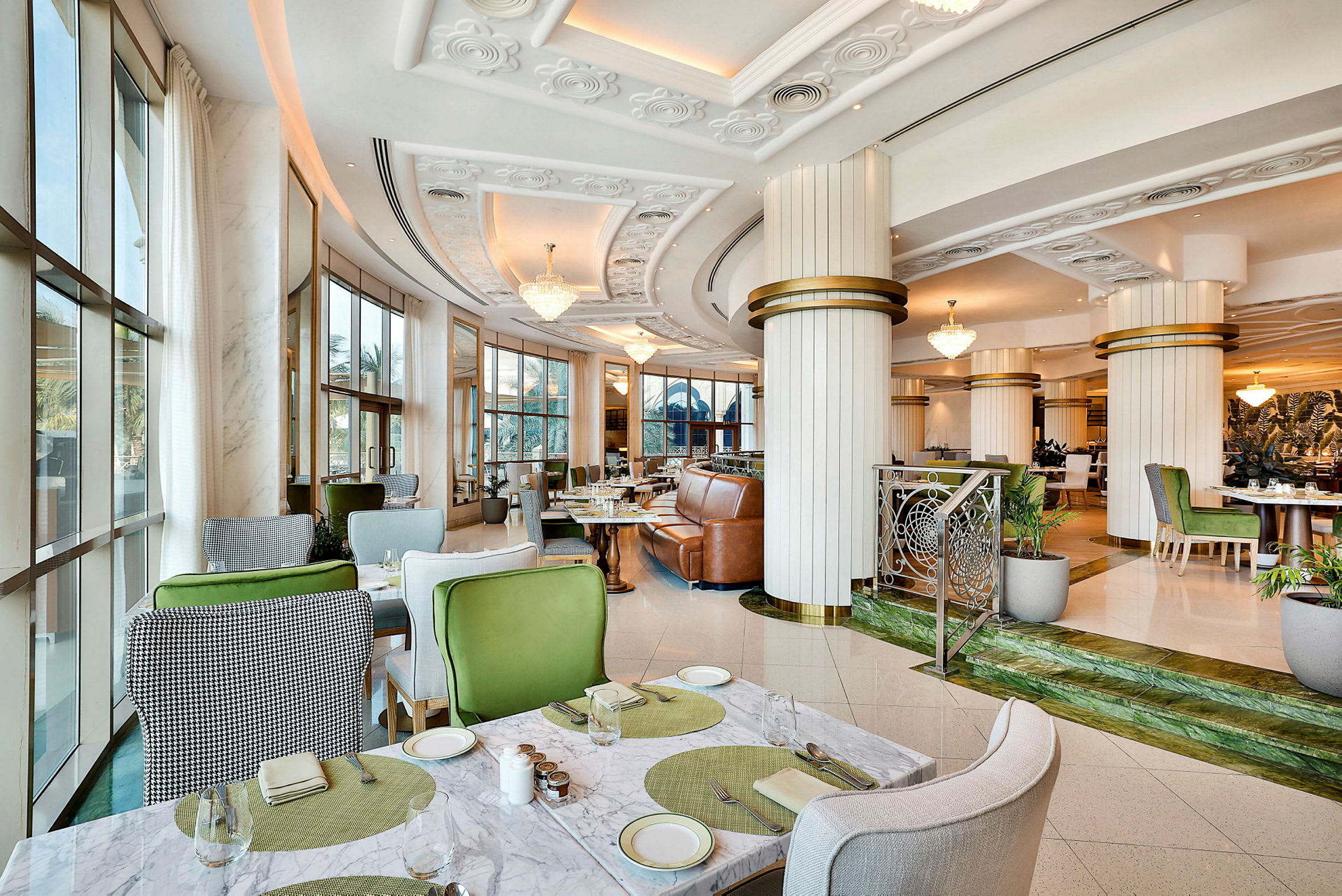 Interiør av en moderne restaurant med elegante møbler og store vinduer. (AI-generert tekst)