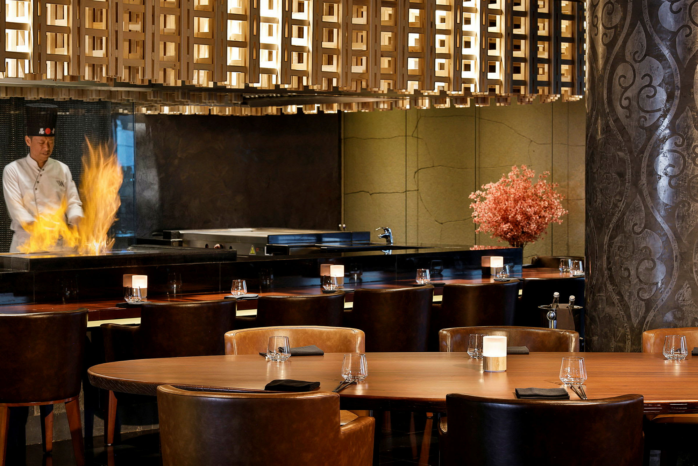 Innredning av en restaurant med bord, stoler og en flamme på en matlagingsflate. (AI-generert tekst)