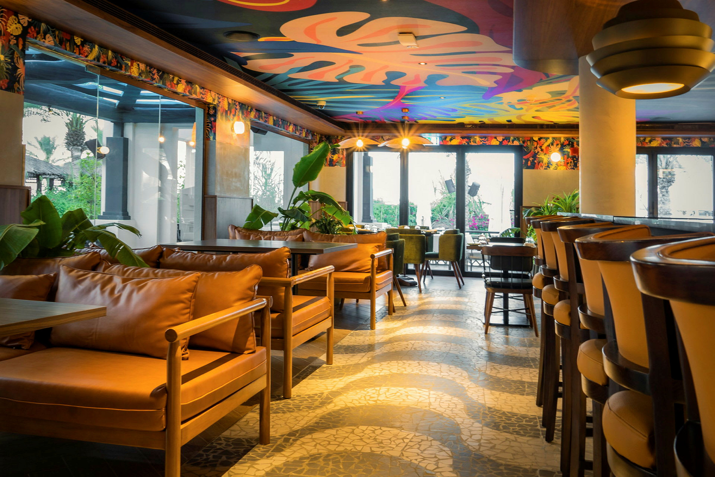 En lys restaurant med fargerikt dekorert tak og moderne sittemøbler. (AI-generert tekst)