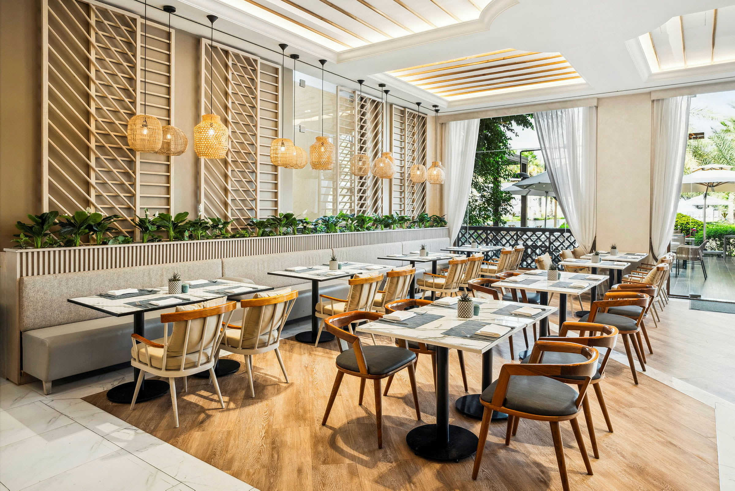 En moderne, lyst innredet restaurant med tremøbler og store vinduer som slipper inn naturlig lys. (AI-generert tekst)