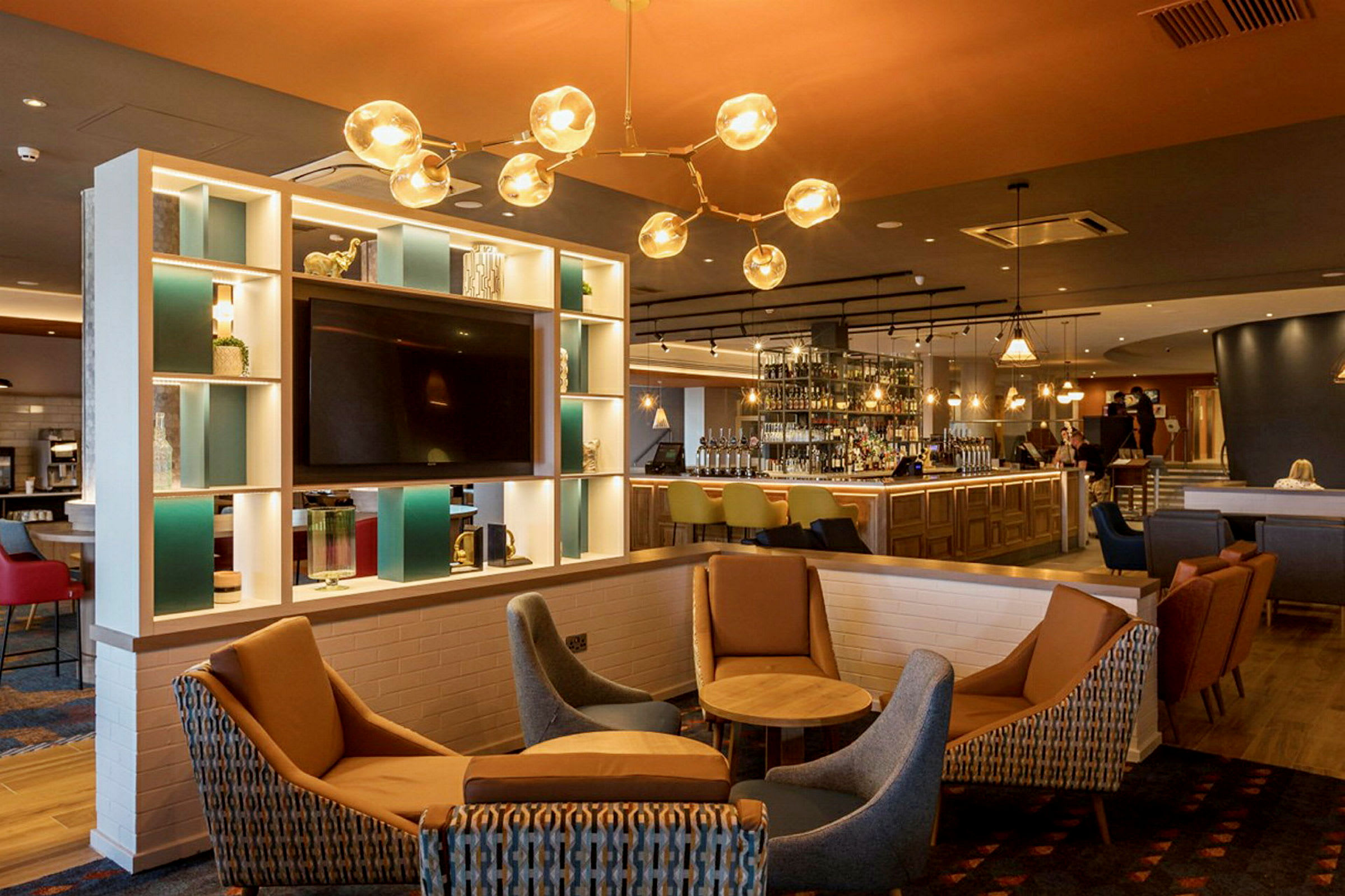 Et moderne hotellområde med en bar, sitteplasser og innredning i lyse farger. (AI-generert tekst)