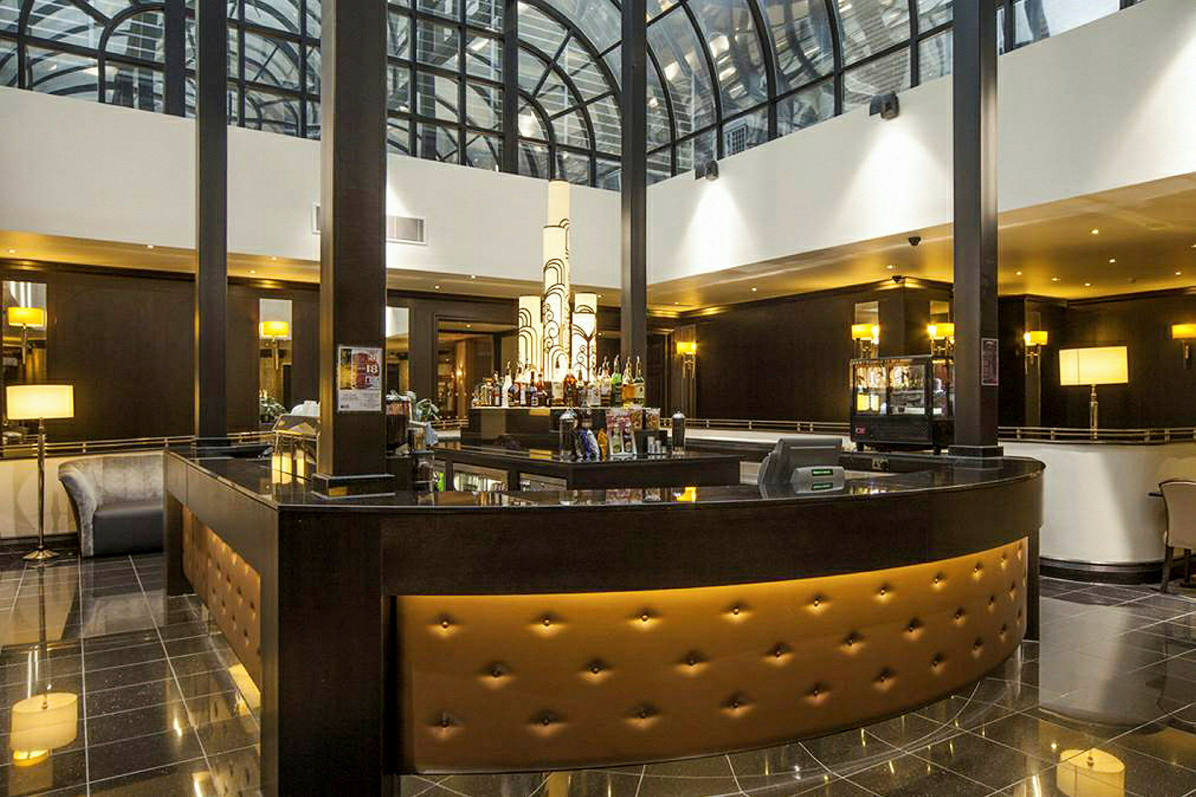 Hotellbar med elegant interiør og glasstak. (AI-generert tekst)