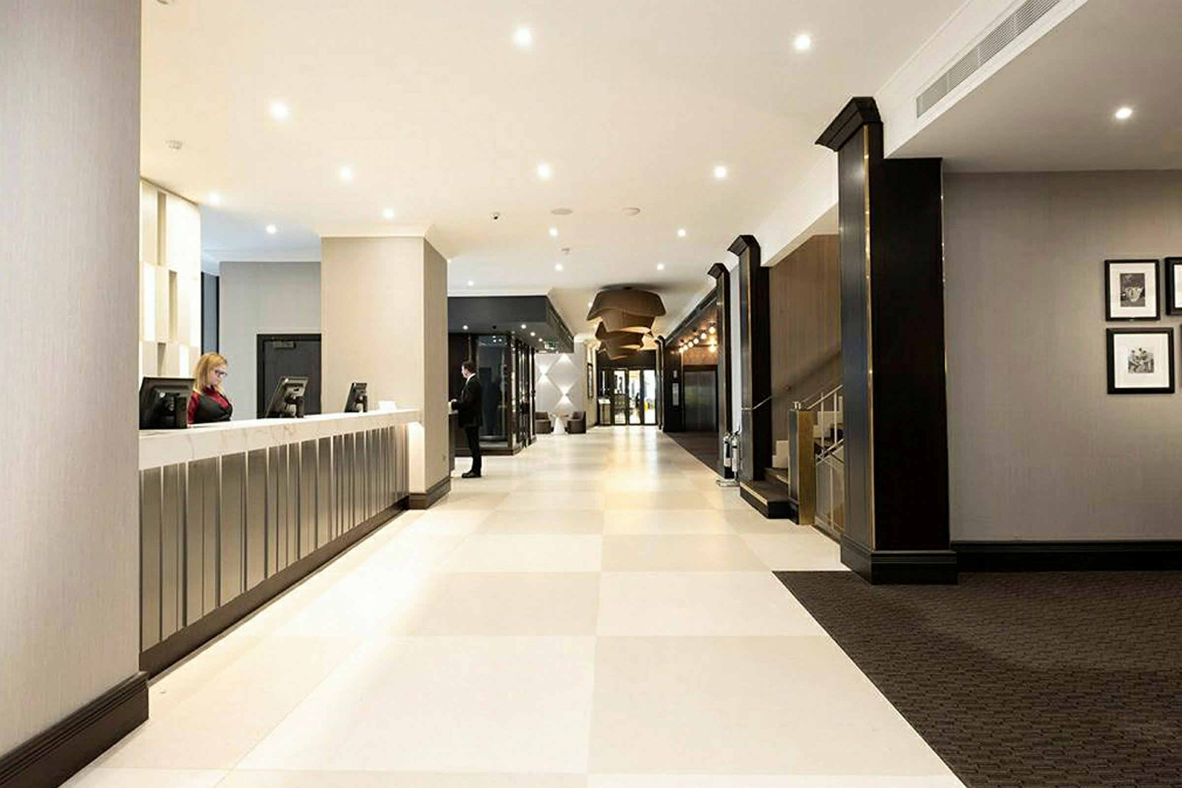 Hotellobby med resepsjonsdisk og lyse gulv. (AI-generert tekst)